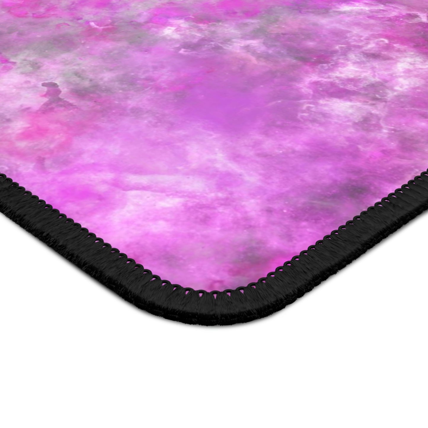 The corner of a gaming mouse pad with a fluffy mix of pink, white, and gray.