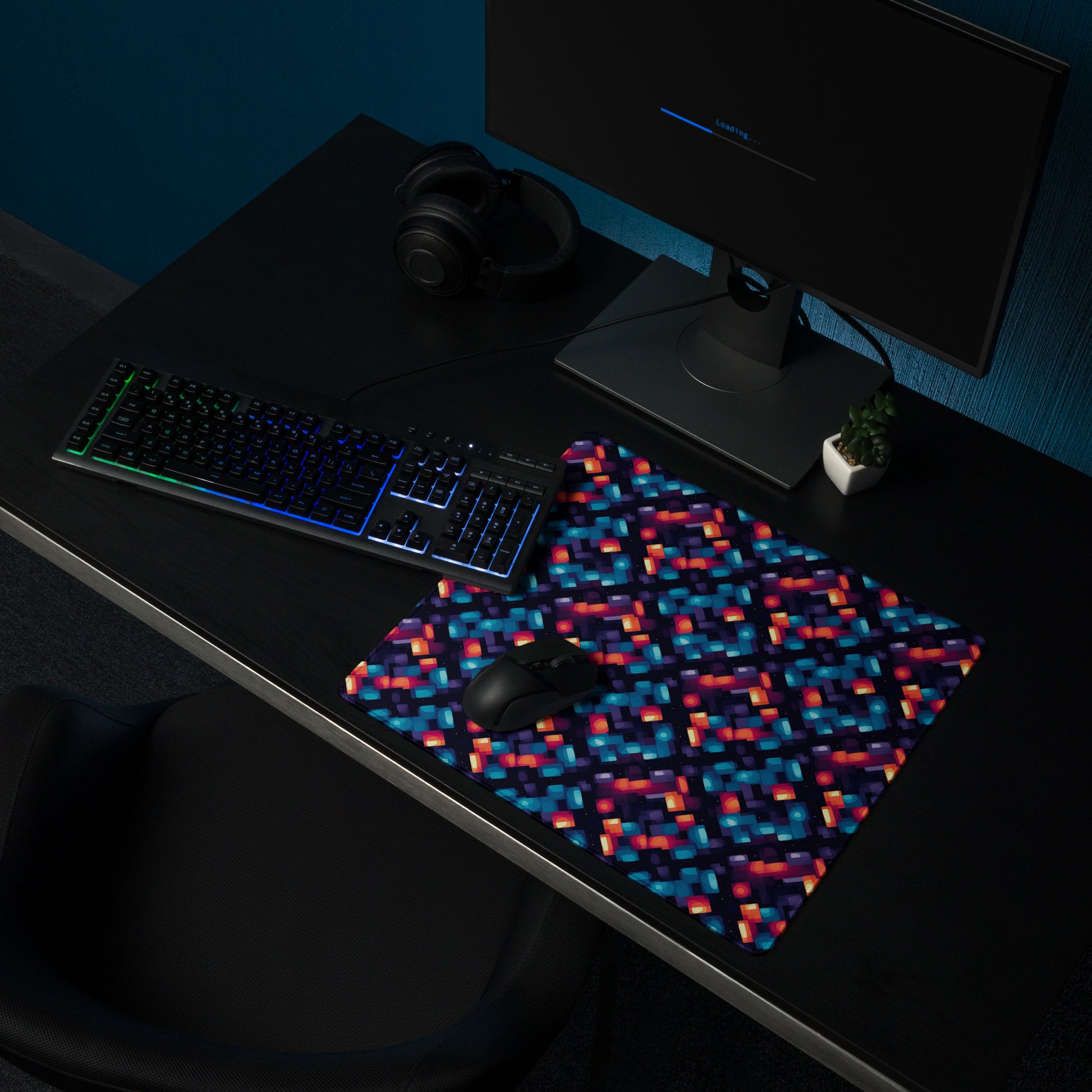 alt text- A 18" x 16" desk pad with blue and orange abstract pattern sitting on a desk.