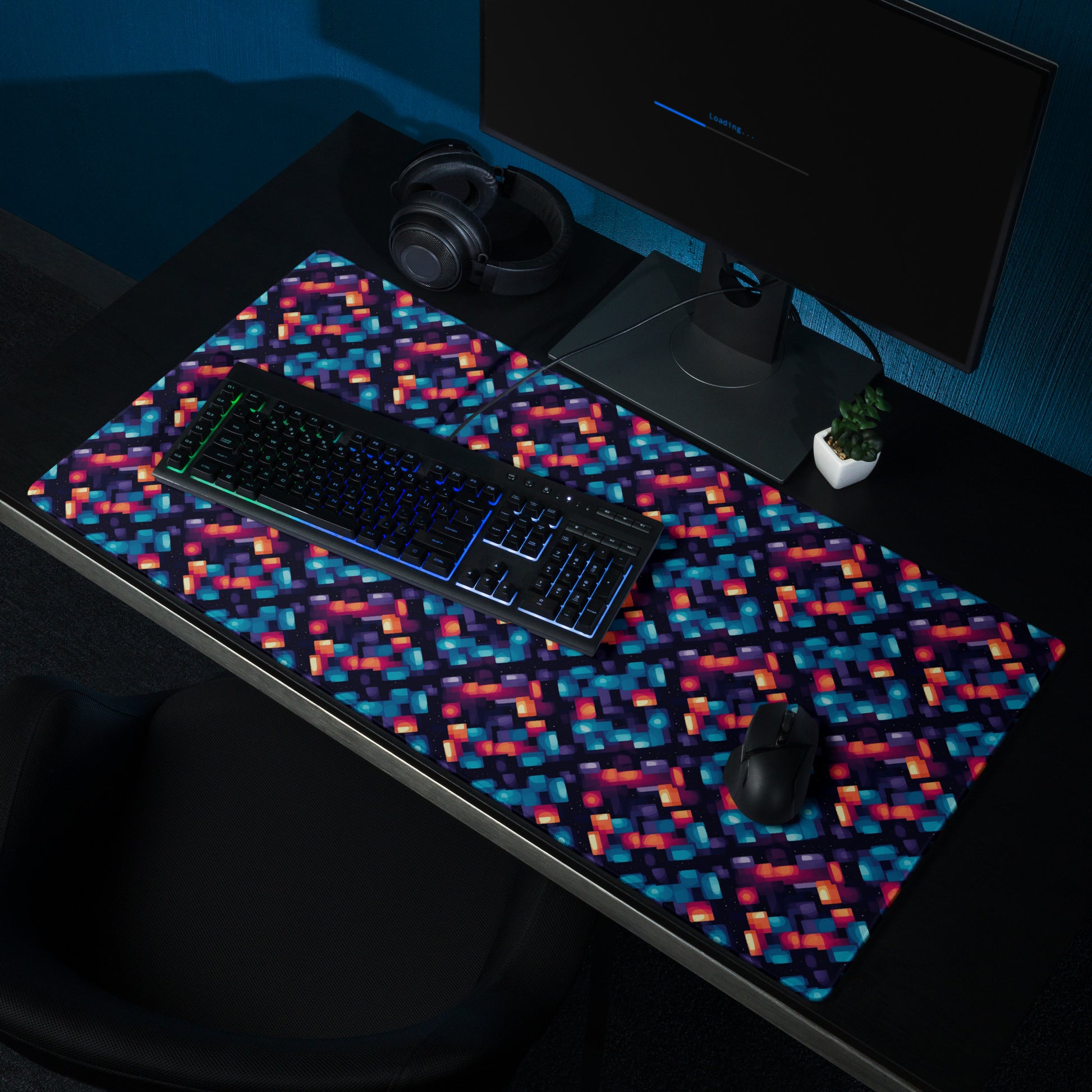 alt text- A 36" x 18" desk pad with blue and orange abstract pattern sitting on a desk.