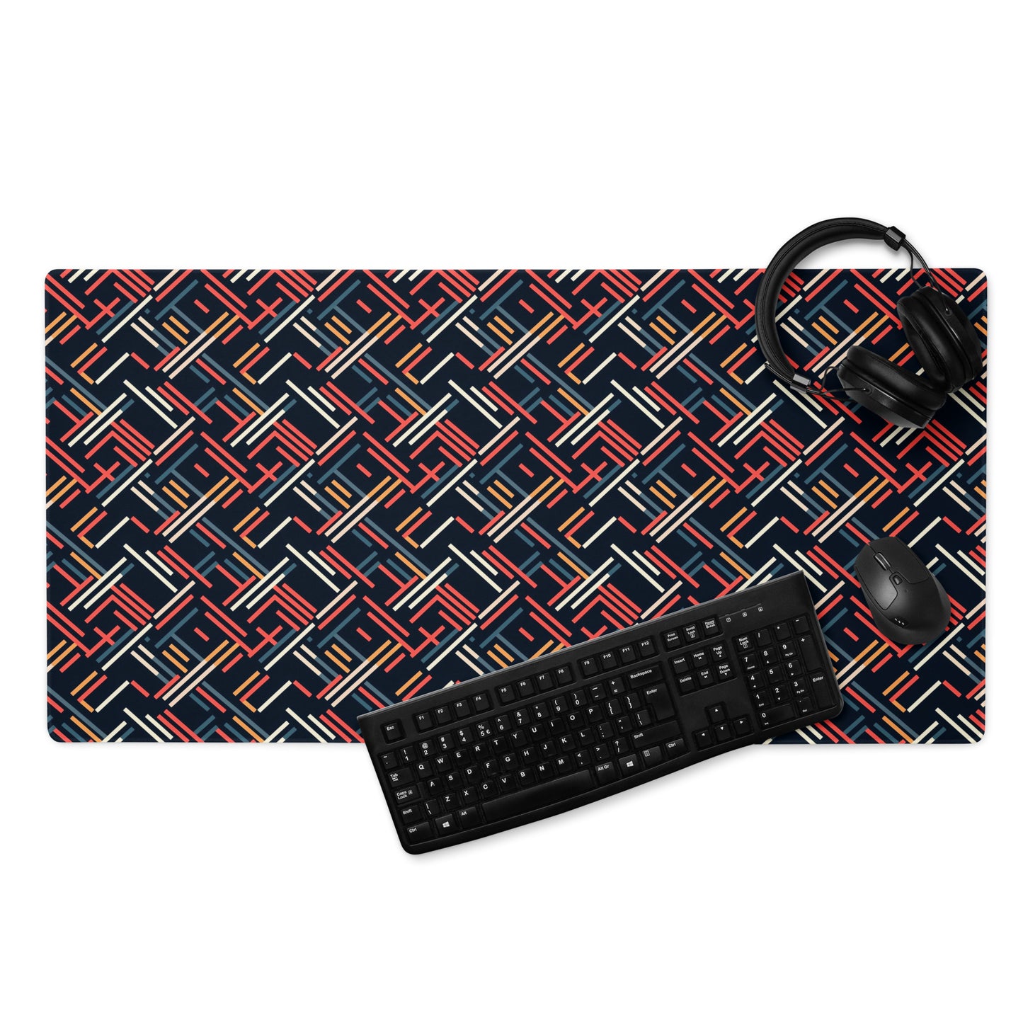A 36" x 18" gaming desk pad with red, blue, white, and orange lines on a black background. A keyboard, mouse, and headphones sit on it.