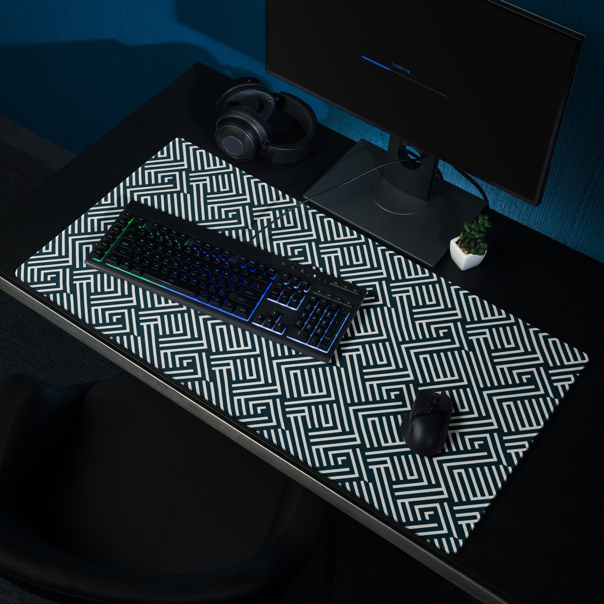 A 36" x 18" gaming desk pad with white lines on a black background. It sits on a black desk with a keyboard, monitor, and mouse.