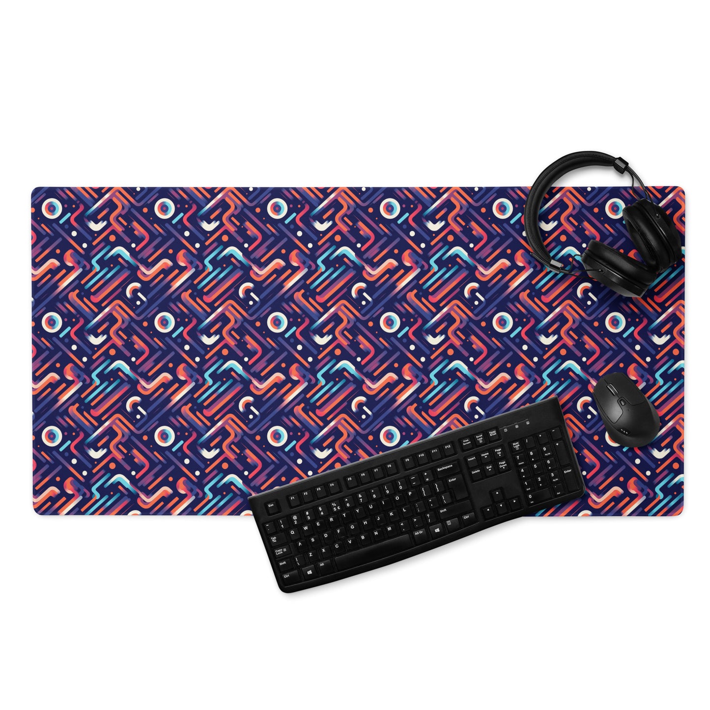 A 36" x 18" gaming desk pad with blue, orange, and purple lines on a dark blue background. A keyboard, mouse, and headphones sit on it.