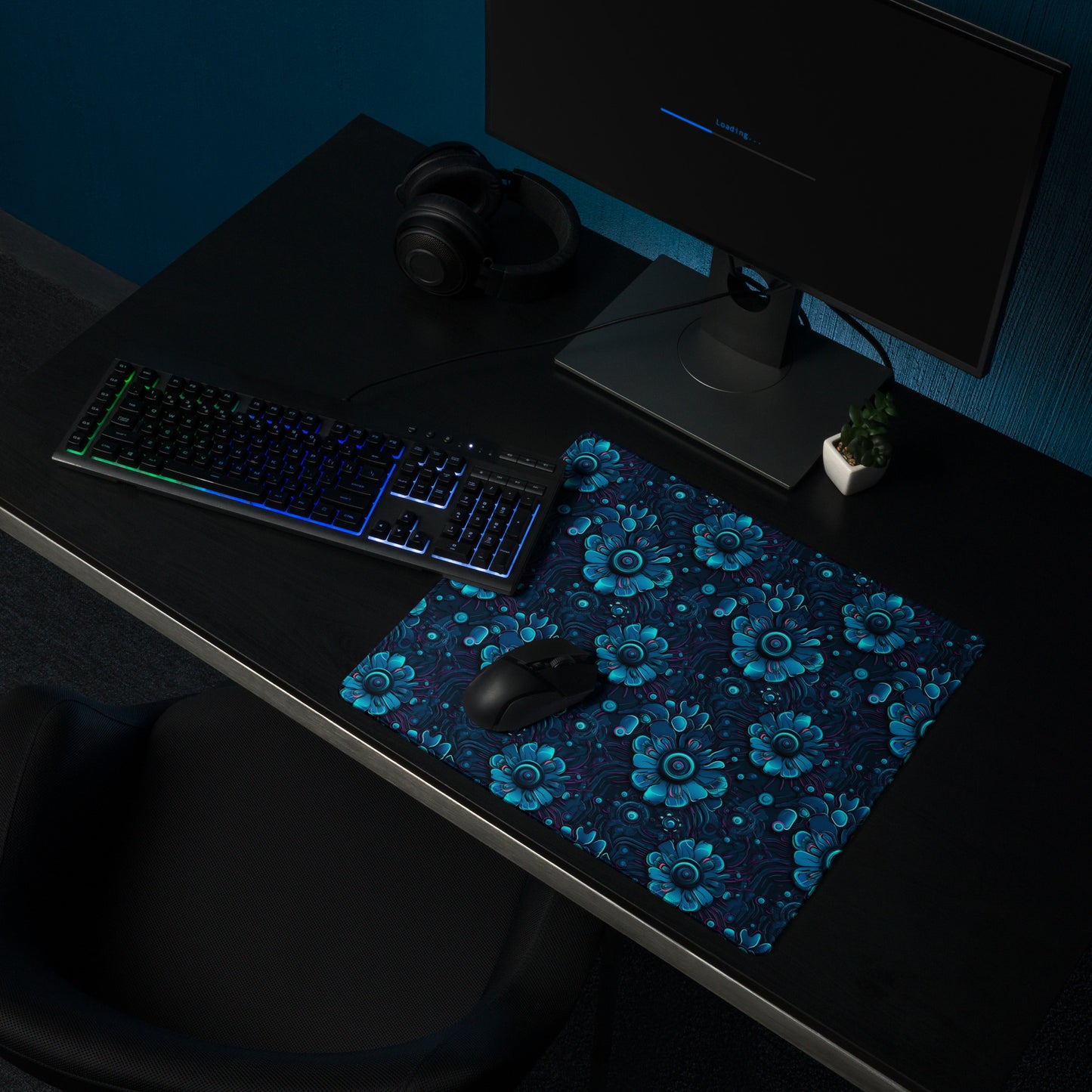 A 18" x 16" desk pad with a blue robotic floral pattern sitting on a desk.