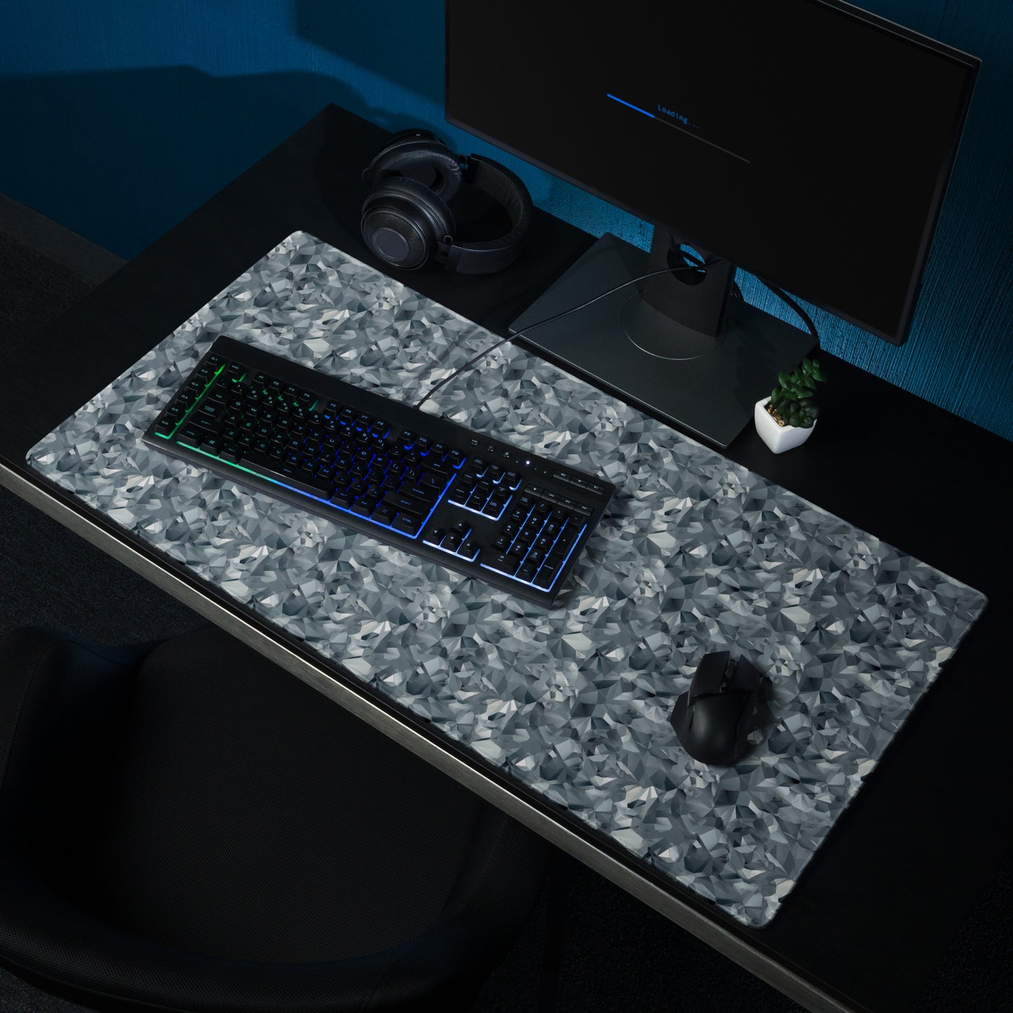 A 36" x 18" gaming desk pad with gray crystals. It sits on a black desk with a monitor, keyboard, and mouse.