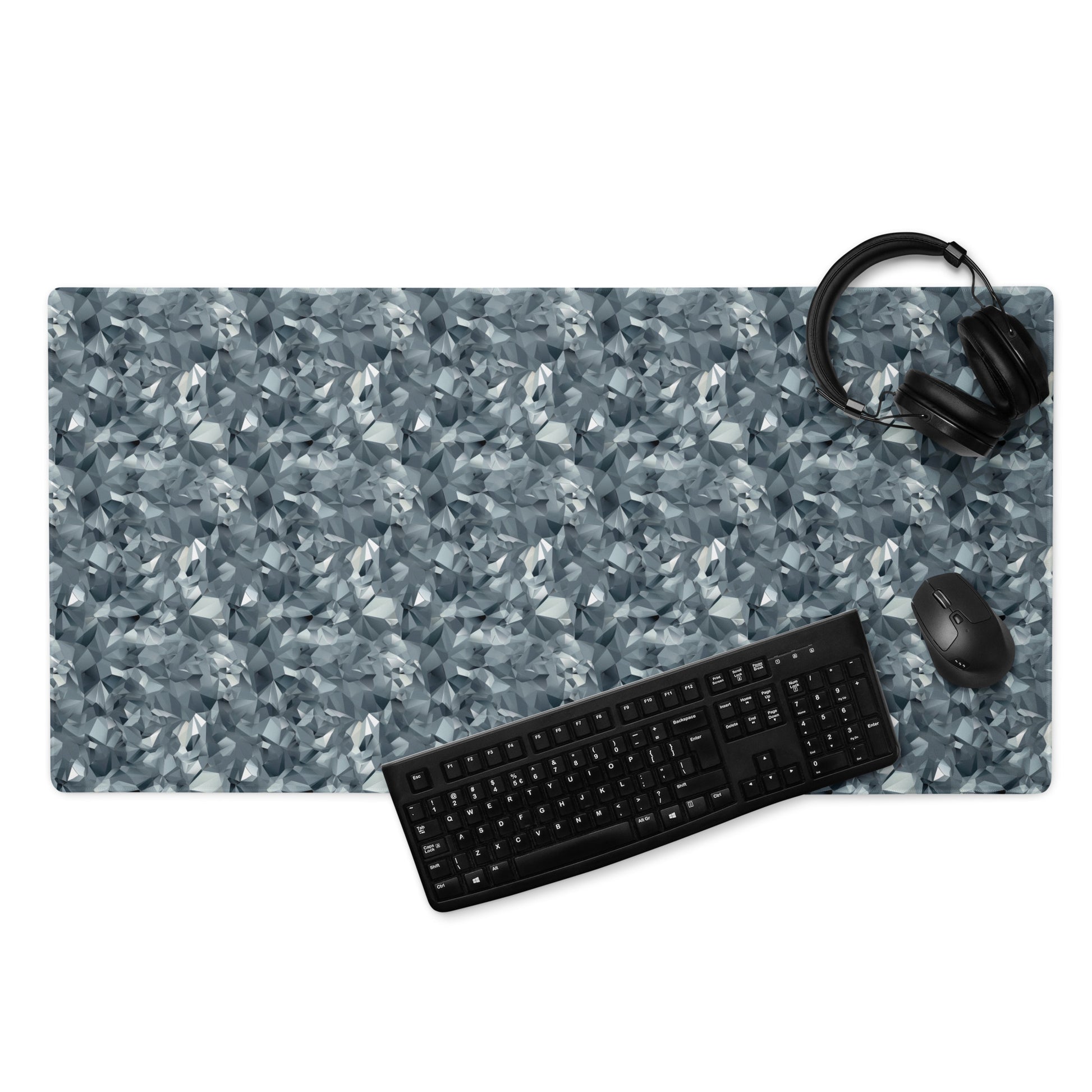 A 36" x 18" gaming desk pad with gray crystals. A keyboard, mouse, and headphones sit on it.