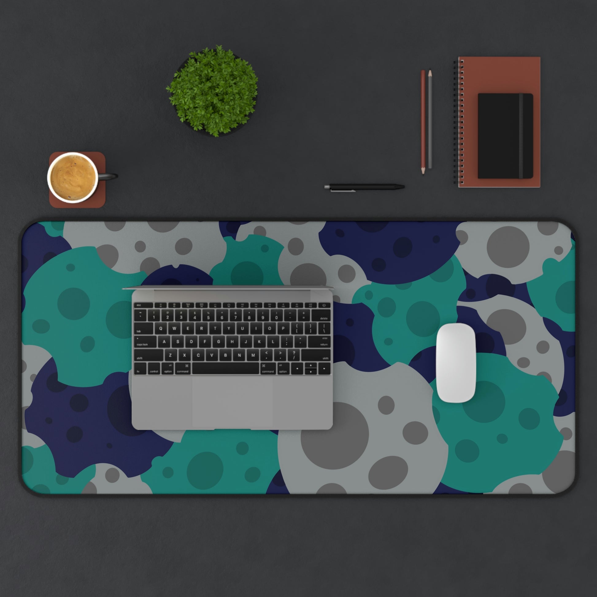 A 31" x 15.5" desk mat with gray, teal, and dark blue meteorites. A laptop and mouse sit on top of it.