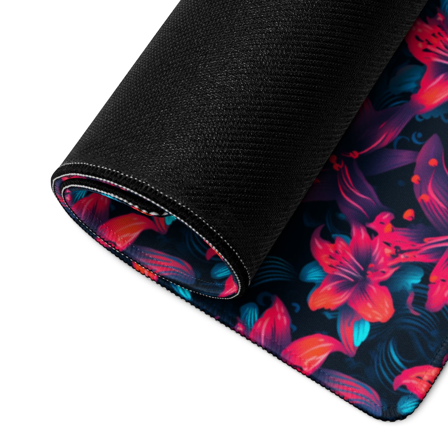 A 36" x 18" desk pad with a neon red and blue floral pattern rolled up.