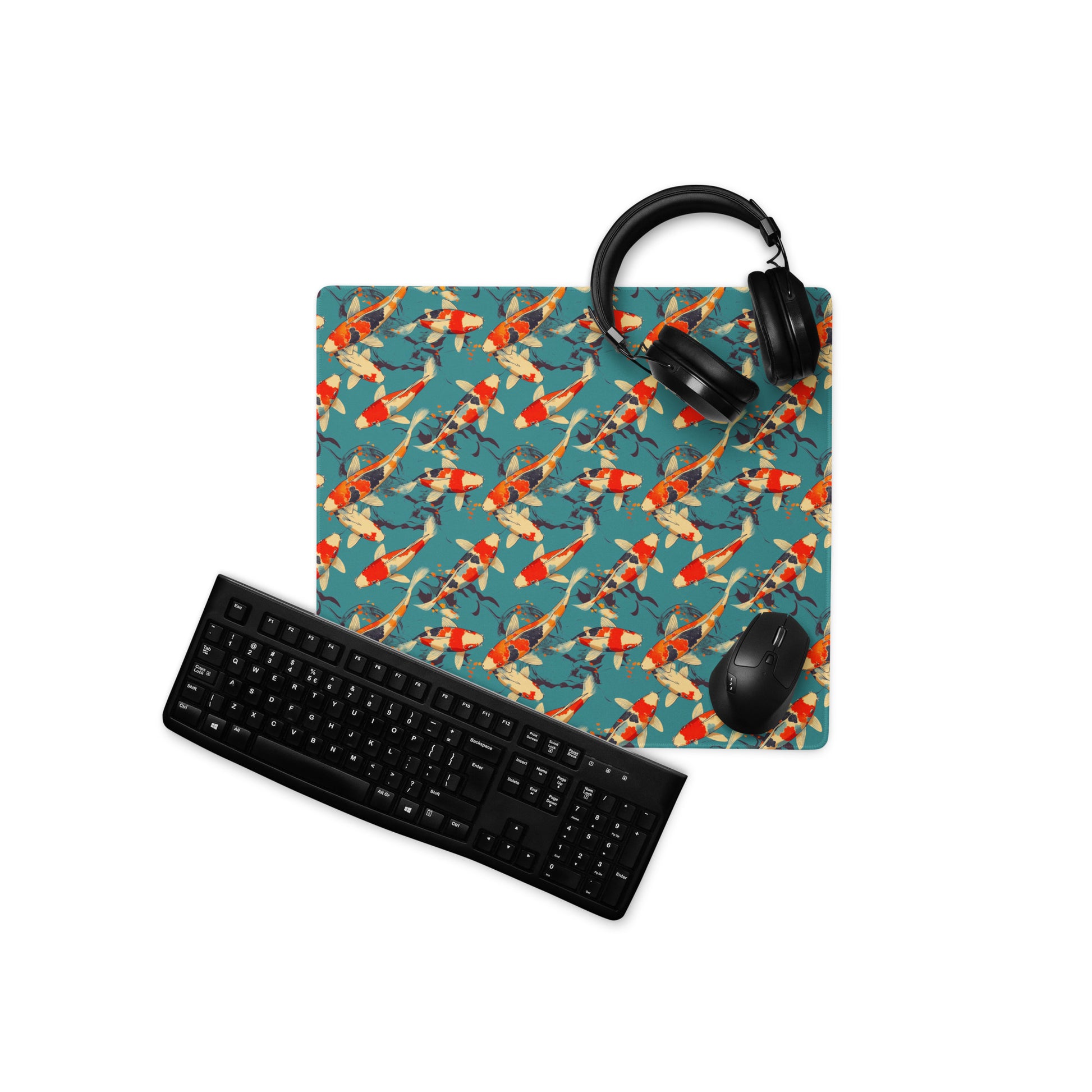 An 18" x 16" gaming desk pad with red koi fish on a blue background. A keyboard, headphones, and mouse sit on top of it.