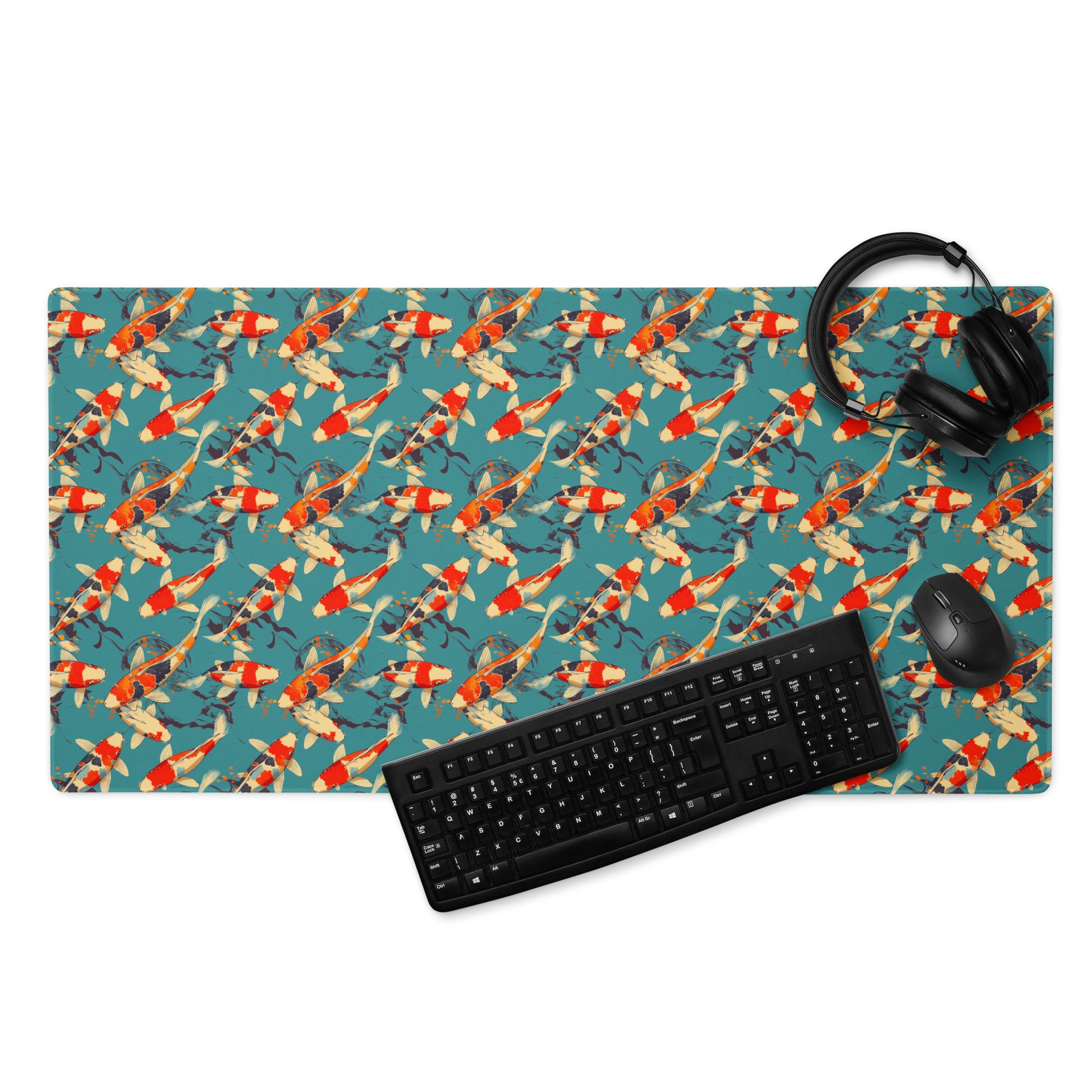 A 36" x 18" gaming desk pad with red koi fish on a blue background. A keyboard, headphones, and mouse sit on top of it.