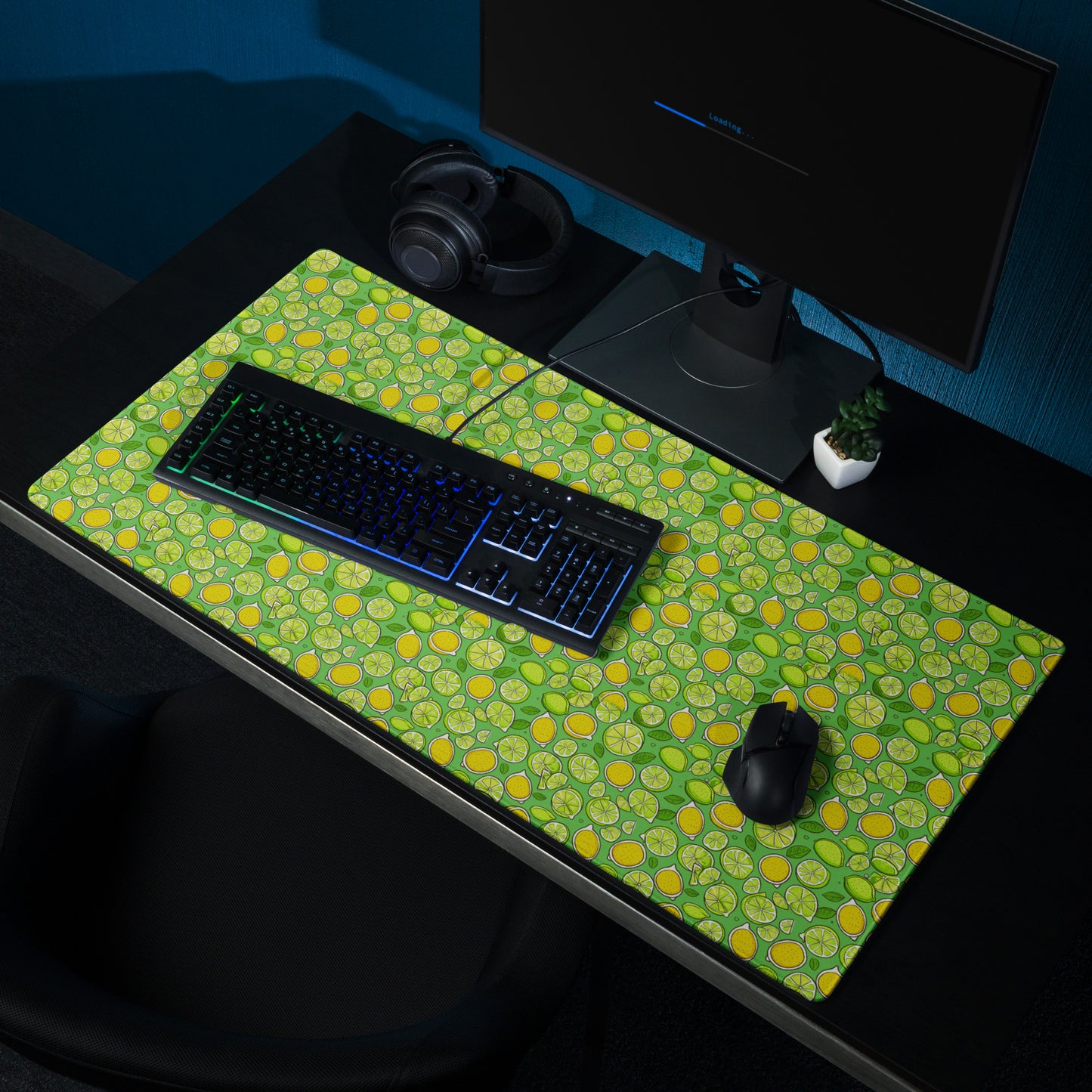 A 36" x 18" gaming desk pad with lemons and limes on a green background. A keyboard and mouse sit on it.