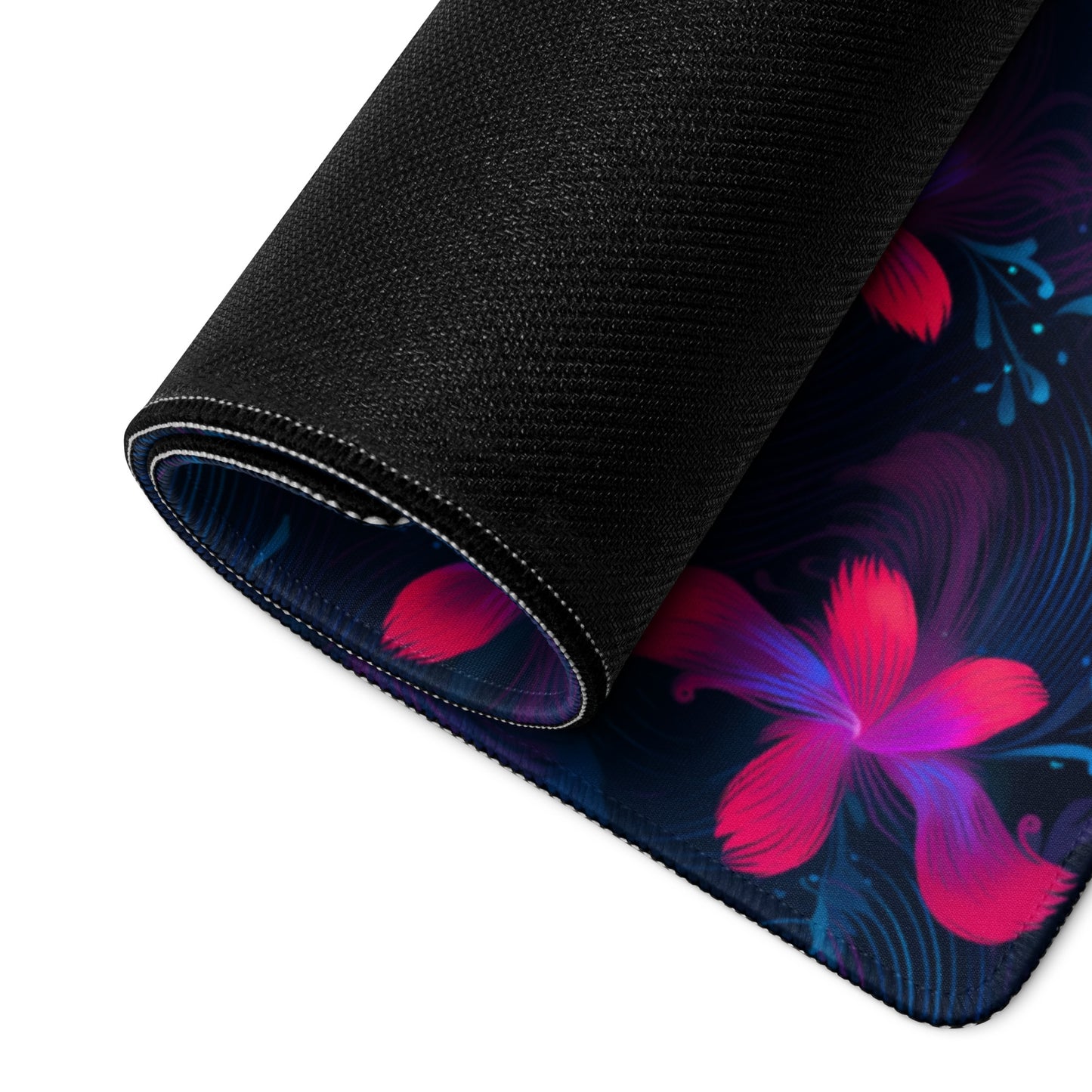 A 36" x 18" desk pad with neon pink and blue floral pattern rolled up.