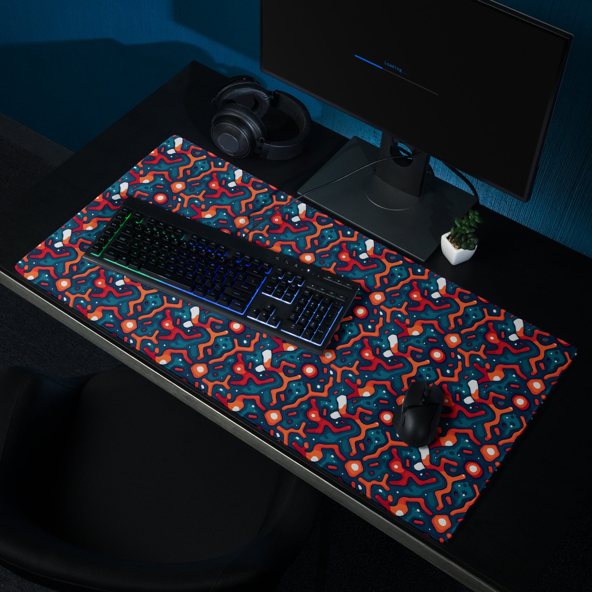 A 36" x 18" desk pad with a blue and orange crack pattern sitting on a desk.