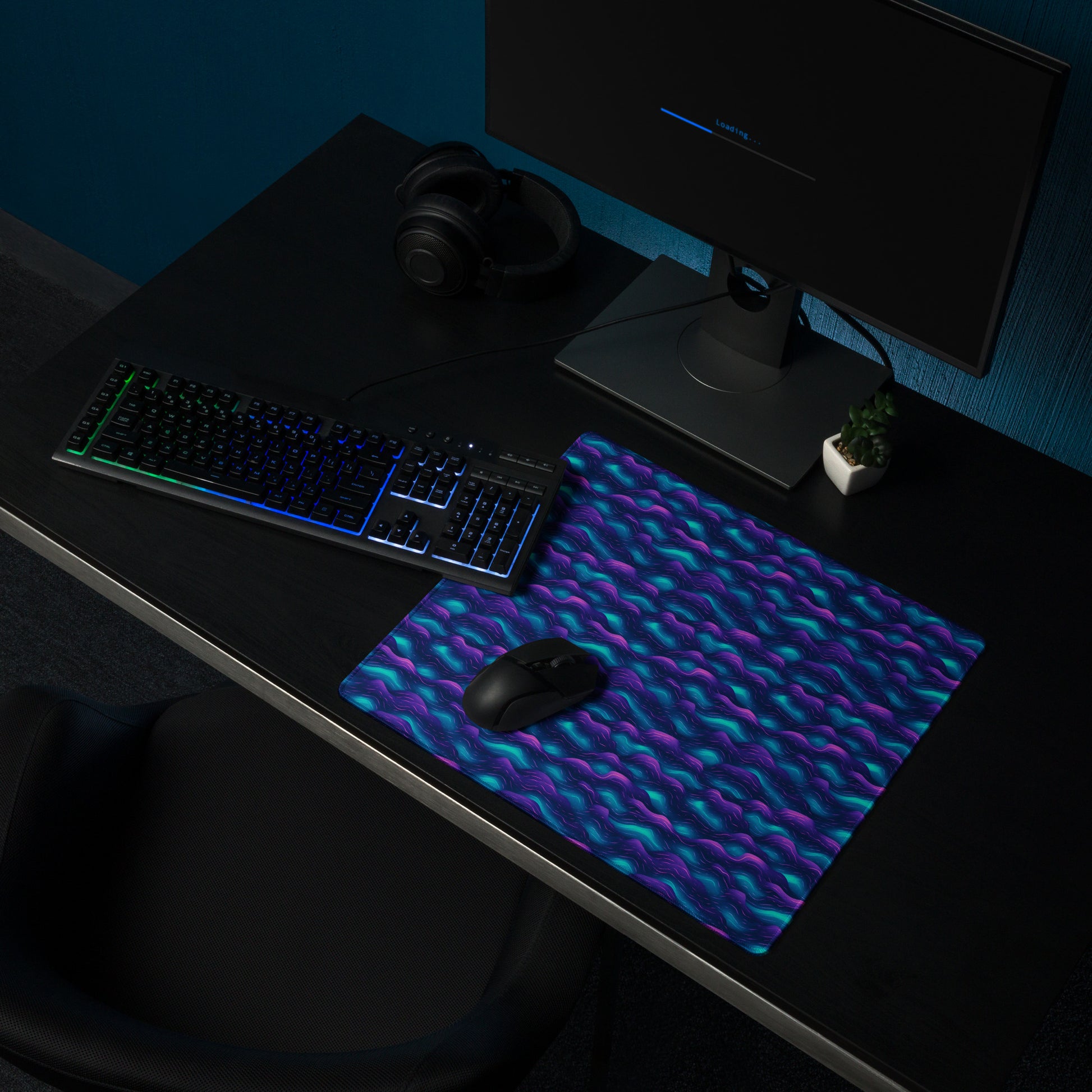 A 18" x 16" desk pad with blue and purple wave pattern sitting on a desk.