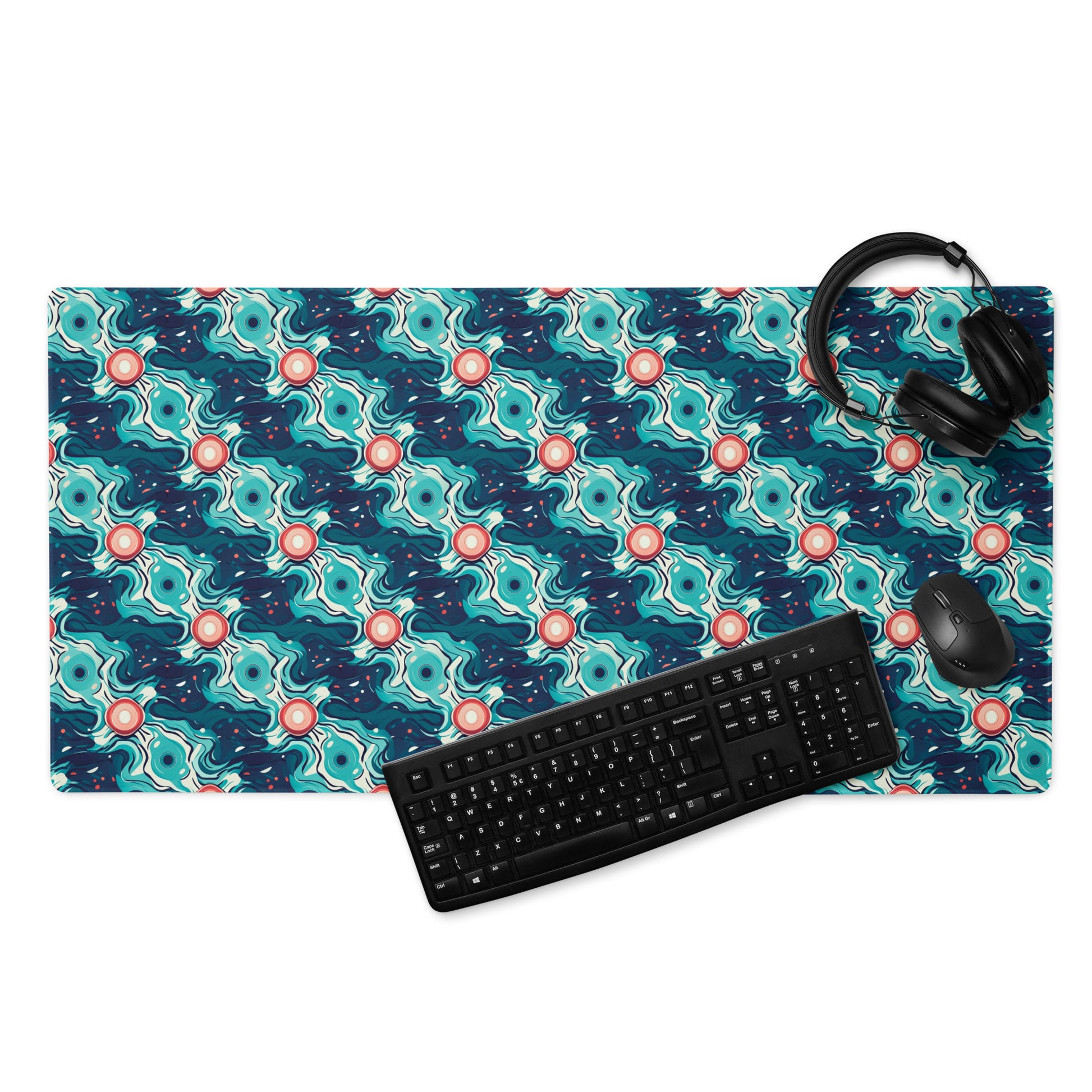 A 36" x 18" desk pad with a teal abstract wavy pattern. With a keyboard, mouse, and headphones sitting on it.