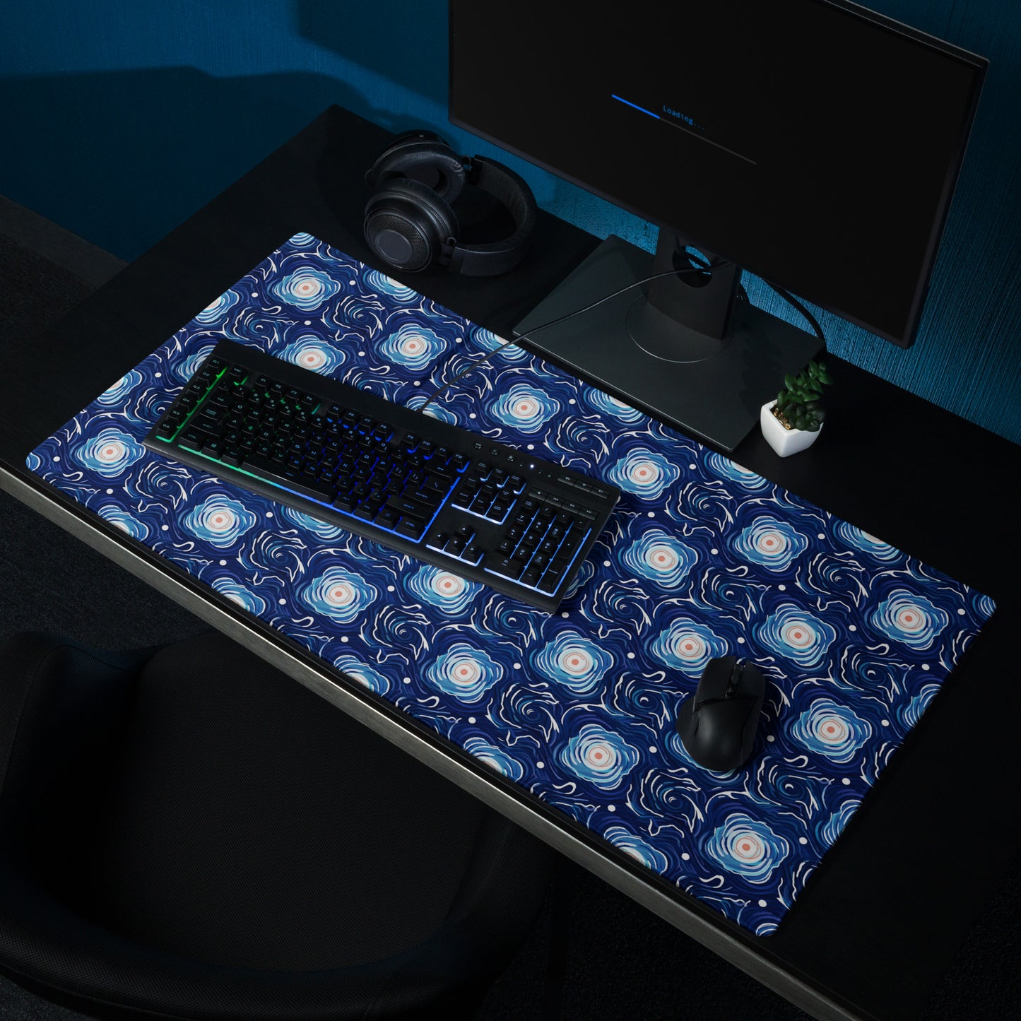A 36" x 18" desk pad with a blue and white floral pattern sitting on a desk.