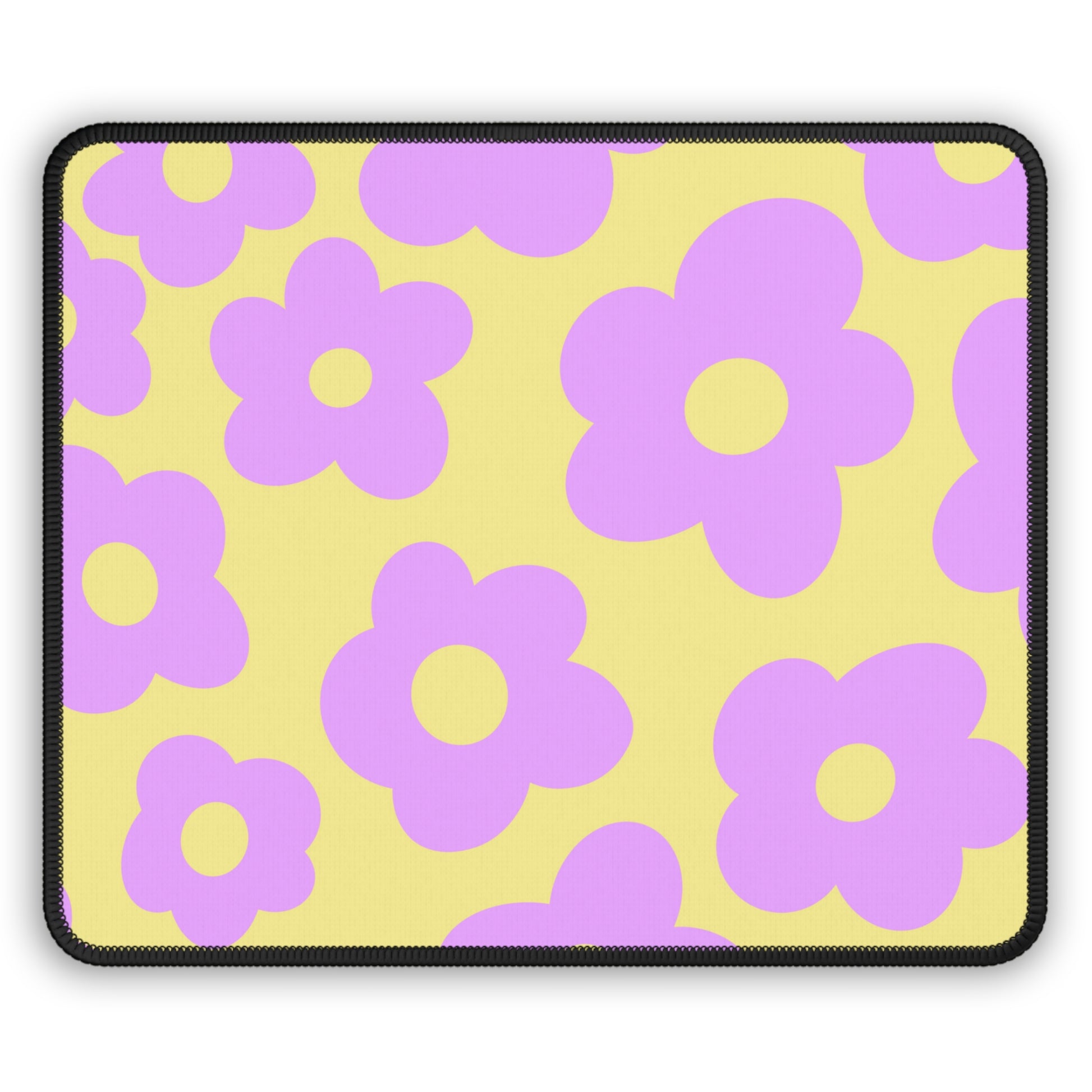 A gaming mouse pad with purple flowers on a yellow background.