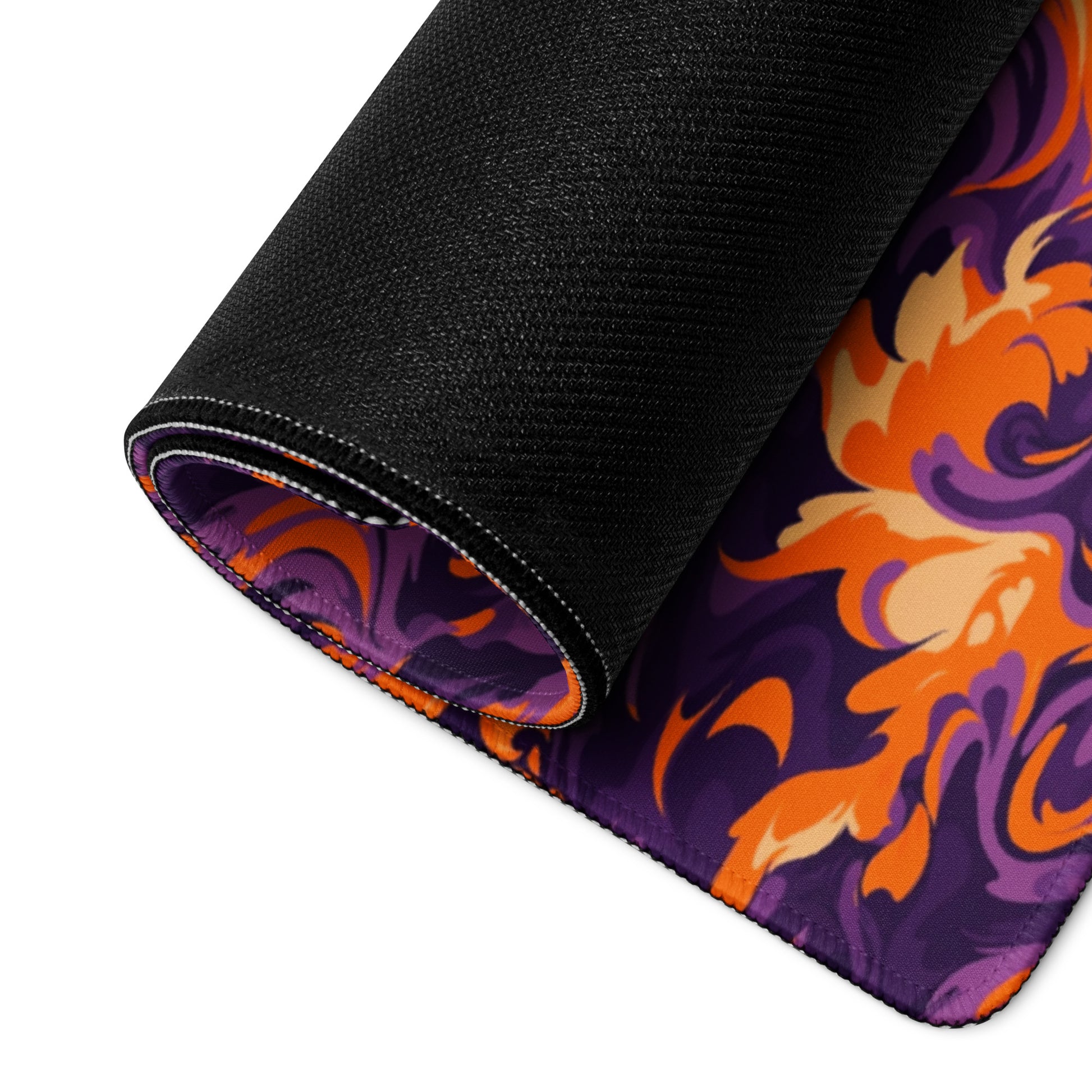 A 36" x 18" desk pad with a purple and orange camo pattern rolled up.