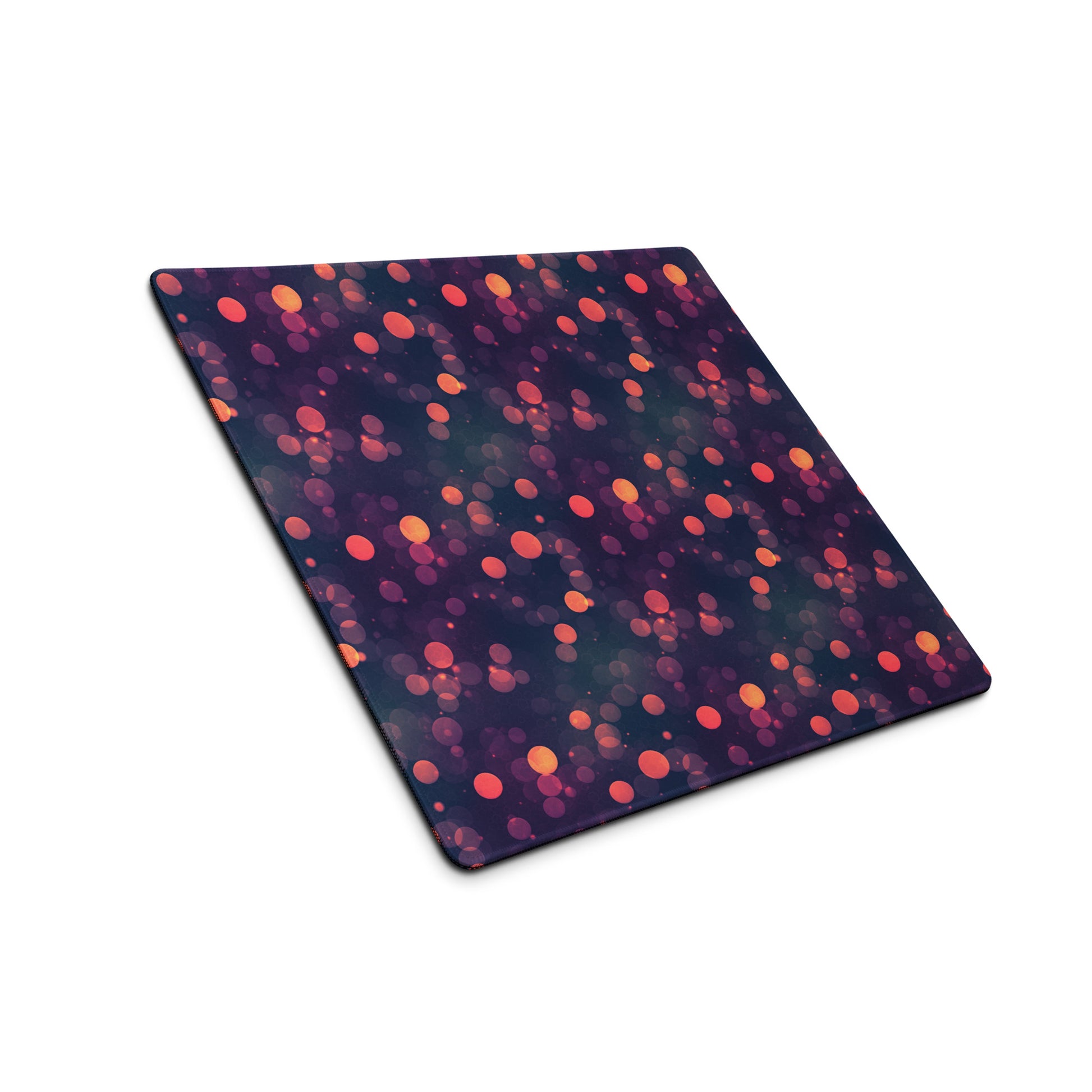 A 18" x 16" desk pad with a purple and red polka dot pattern sitting at an angle.