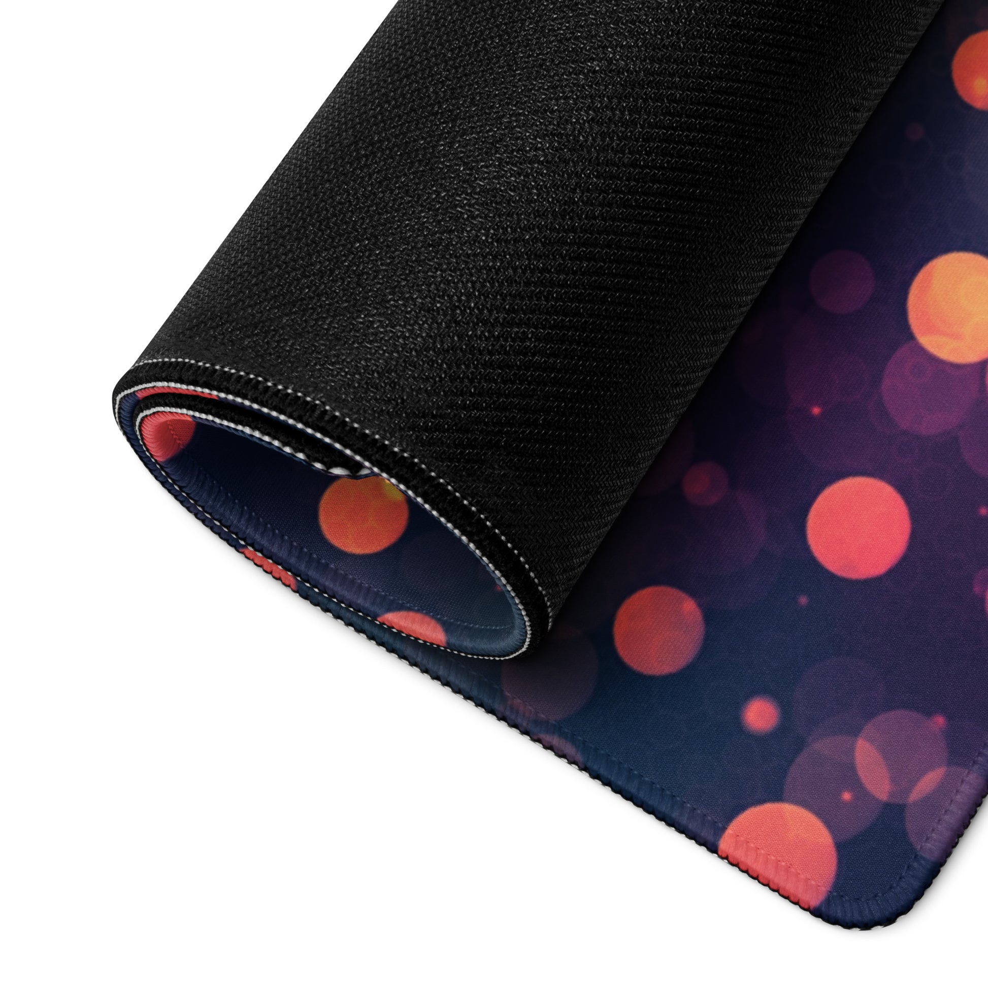 A 36" x 18" desk pad with a purple and red polka dot pattern rolled up.