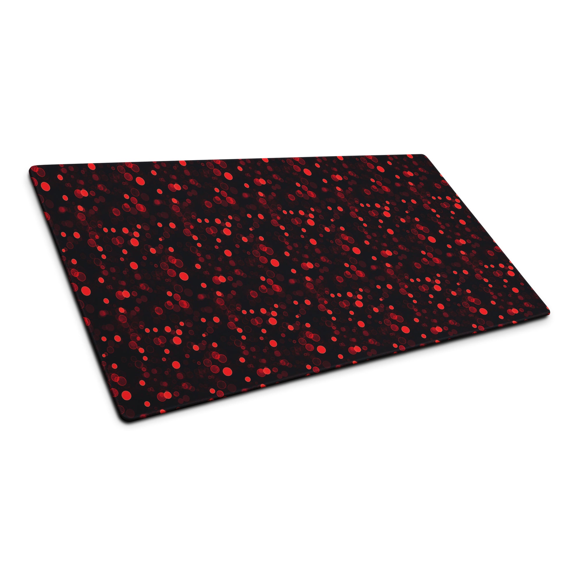 A 36" x 18" desk pad with red polka dots sitting at an angle.