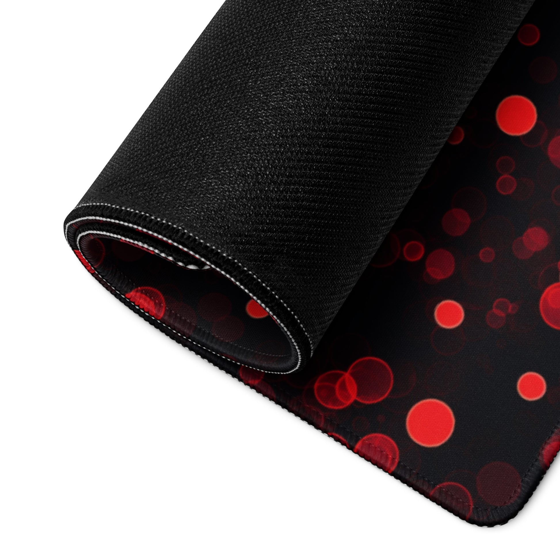A 36" x 18" desk pad with red polka dots rolled up.