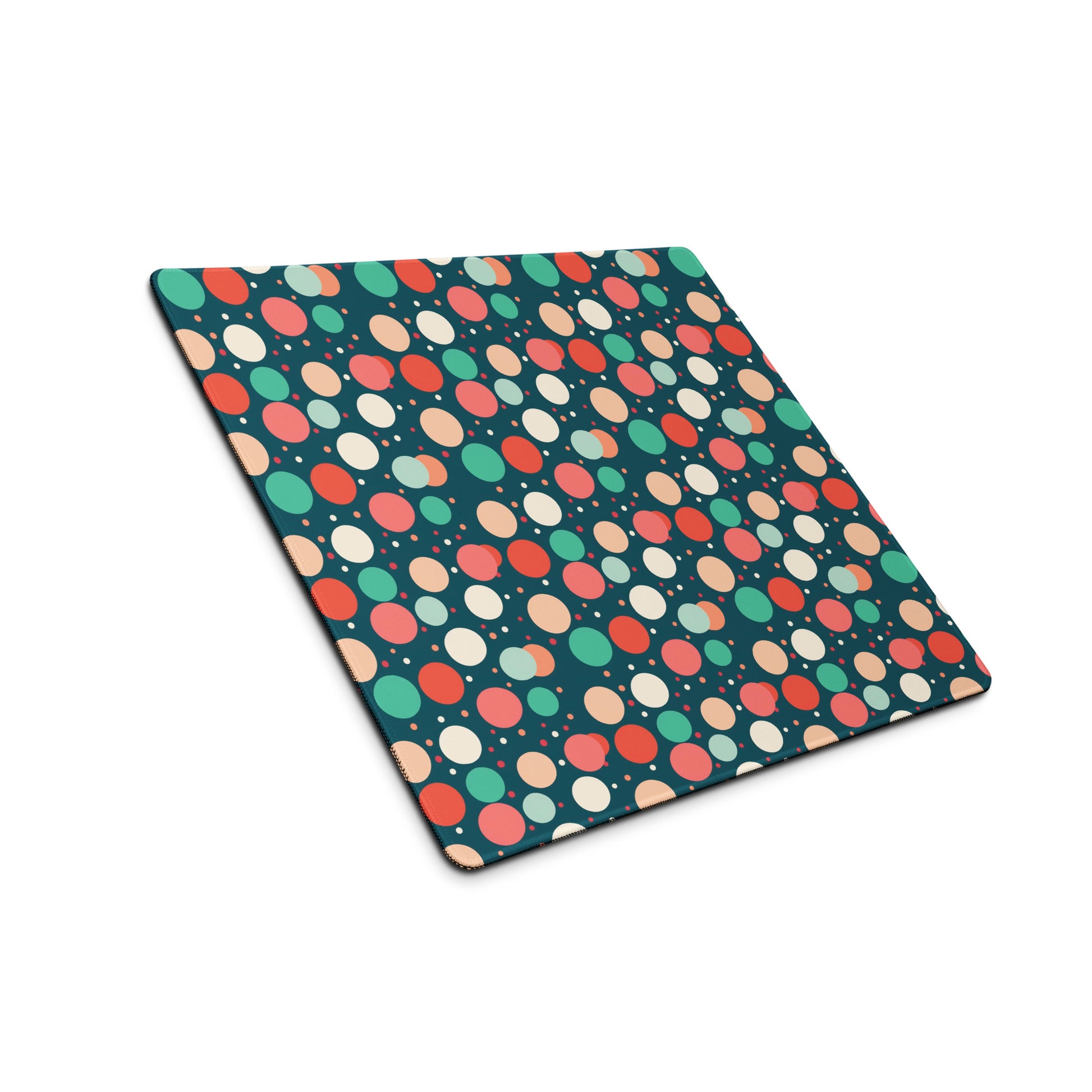  A 18" x 16" desk pad with red teal and yellow polka dot pattern sitting at an angle.
