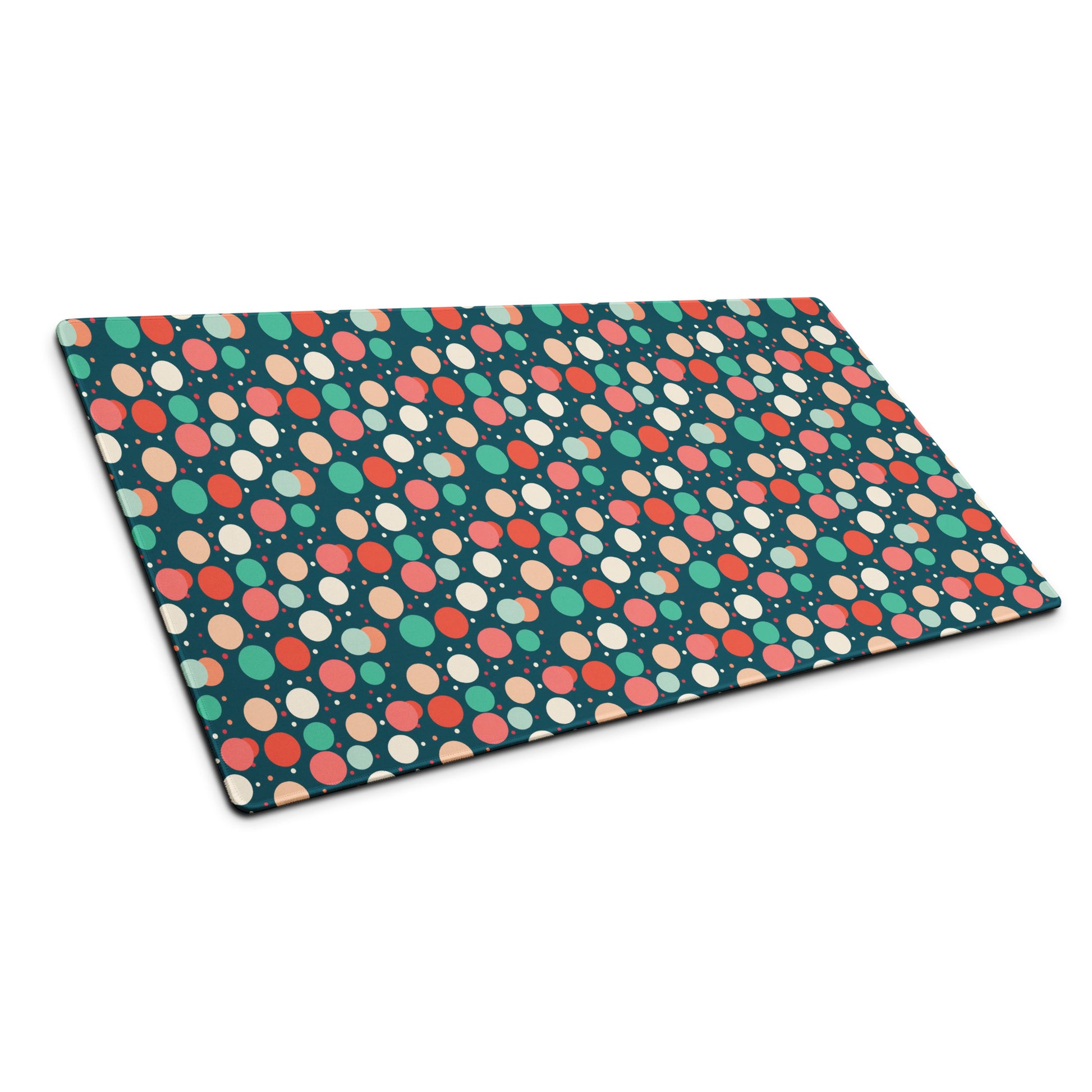  A 36" x 18" desk pad with red teal and yellow polka dot pattern sitting at an angle.