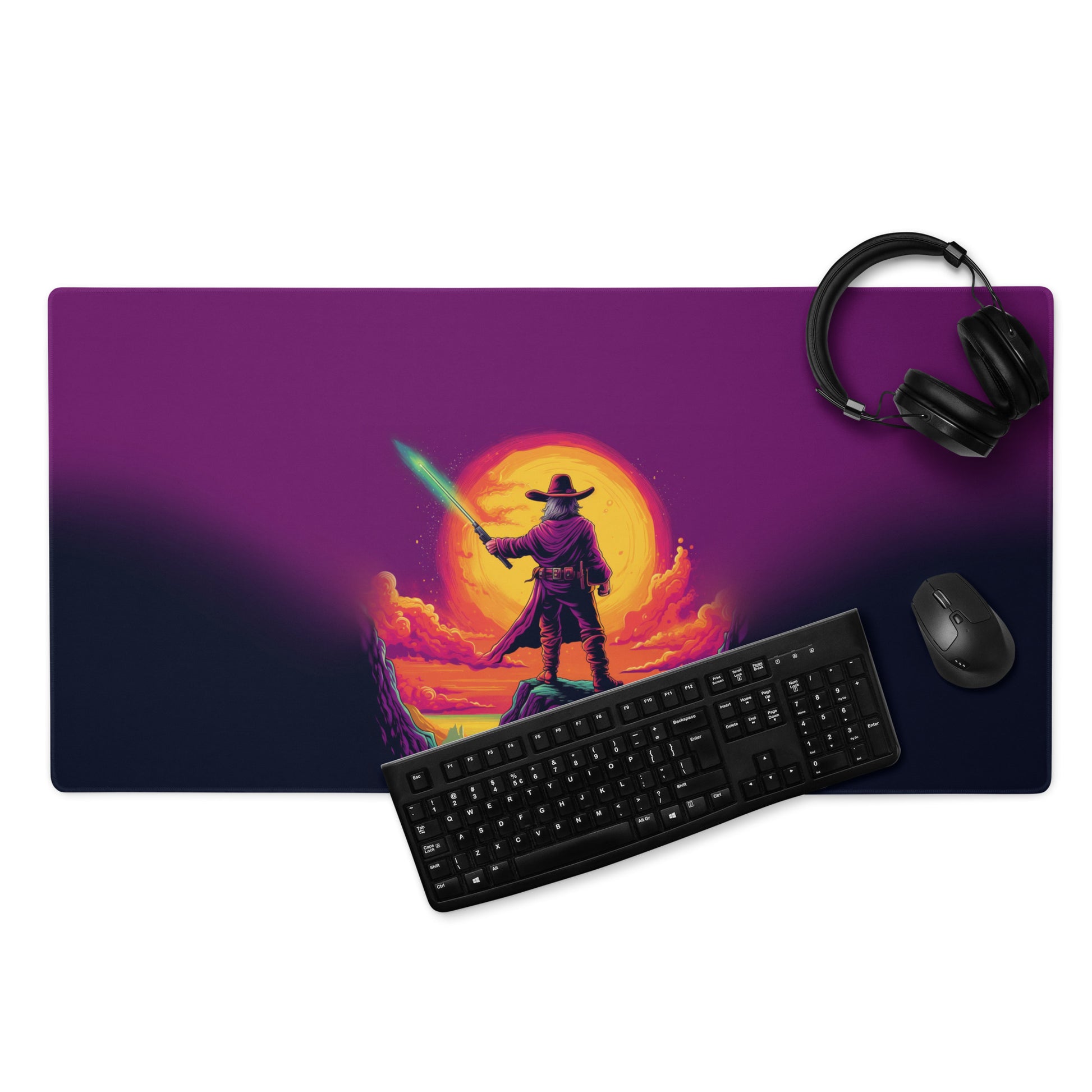 A 36" x 18" desk pad with a cowboy holding a glowing sword looking at the sunset. With a keyboard, mouse, and headphones sitting on it.