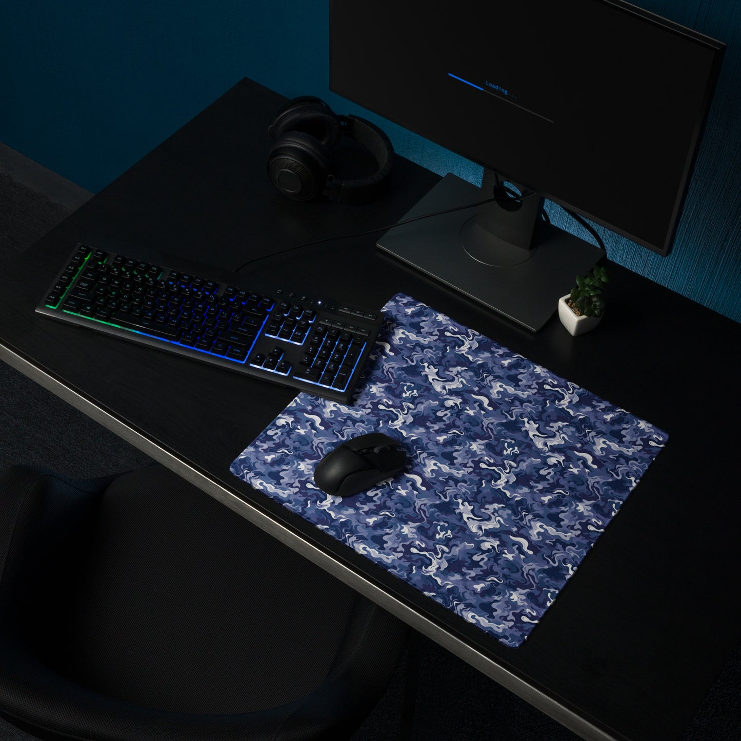 A 18" x 16" desk pad with a royal blue and white camo pattern sitting on a desk.
