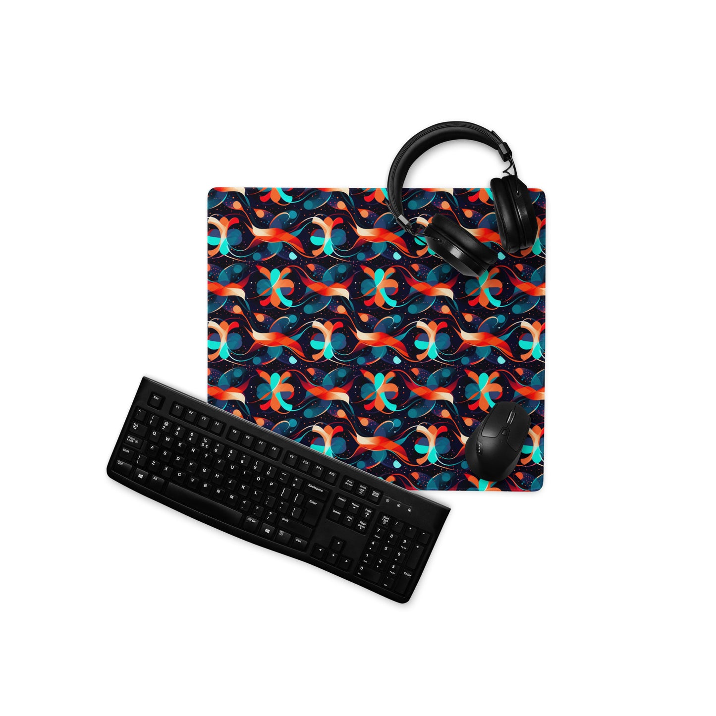 A 18" x 16" desk pad with a wavy orange and blue pattern. With a keyboard, mouse, and headphones sitting on it.