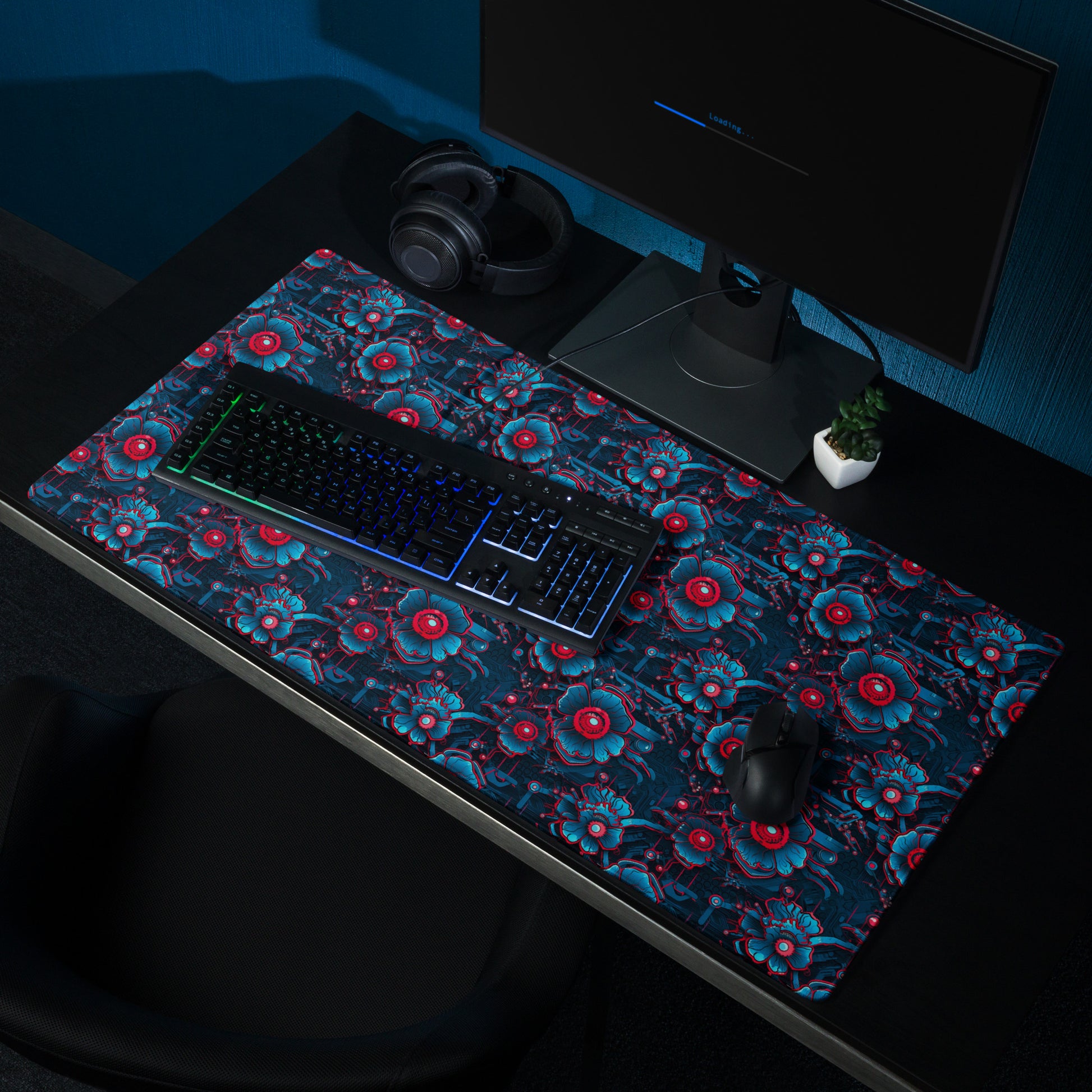 A 36" x 18" desk pad with a blue and red robotic floral pattern sitting on a desk.