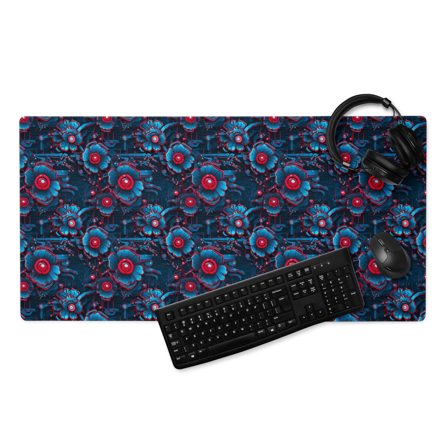 A 36" x 18" desk pad with a blue and red robotic floral pattern. With a keyboard, mouse, and headphones sitting on it.