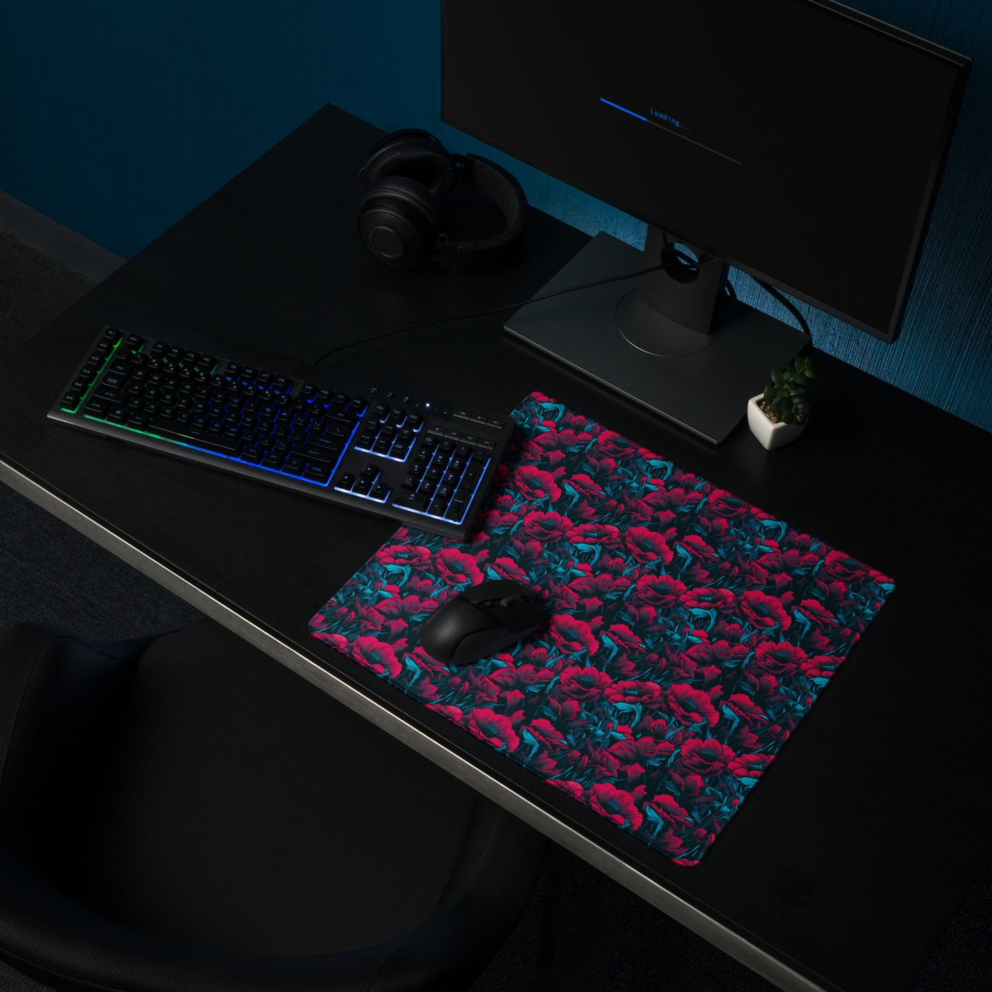 A 18" x 16" desk pad with a red and blue floral pattern sitting on a desk.