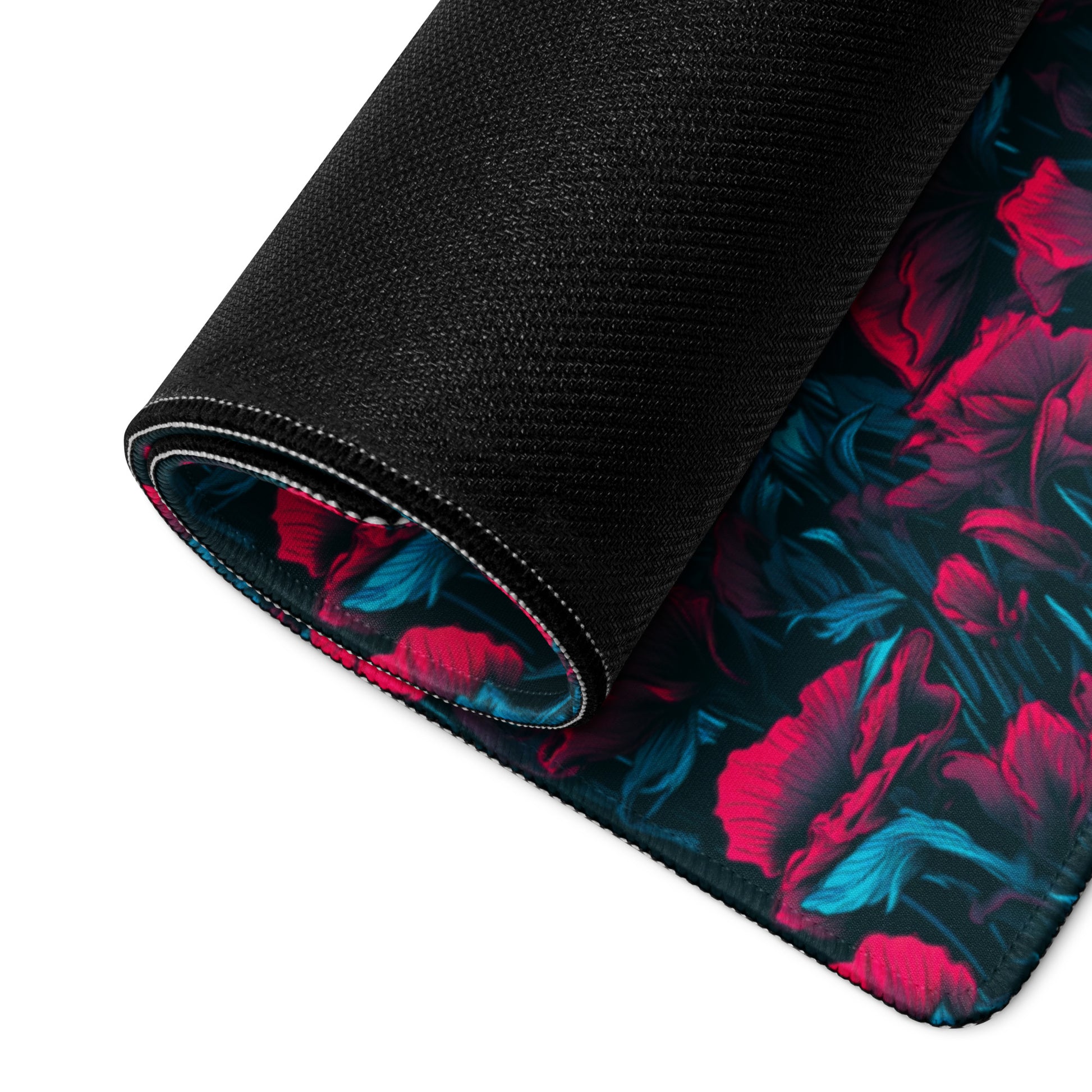 A 36" x 18" desk pad with a red and blue floral pattern rolled up.