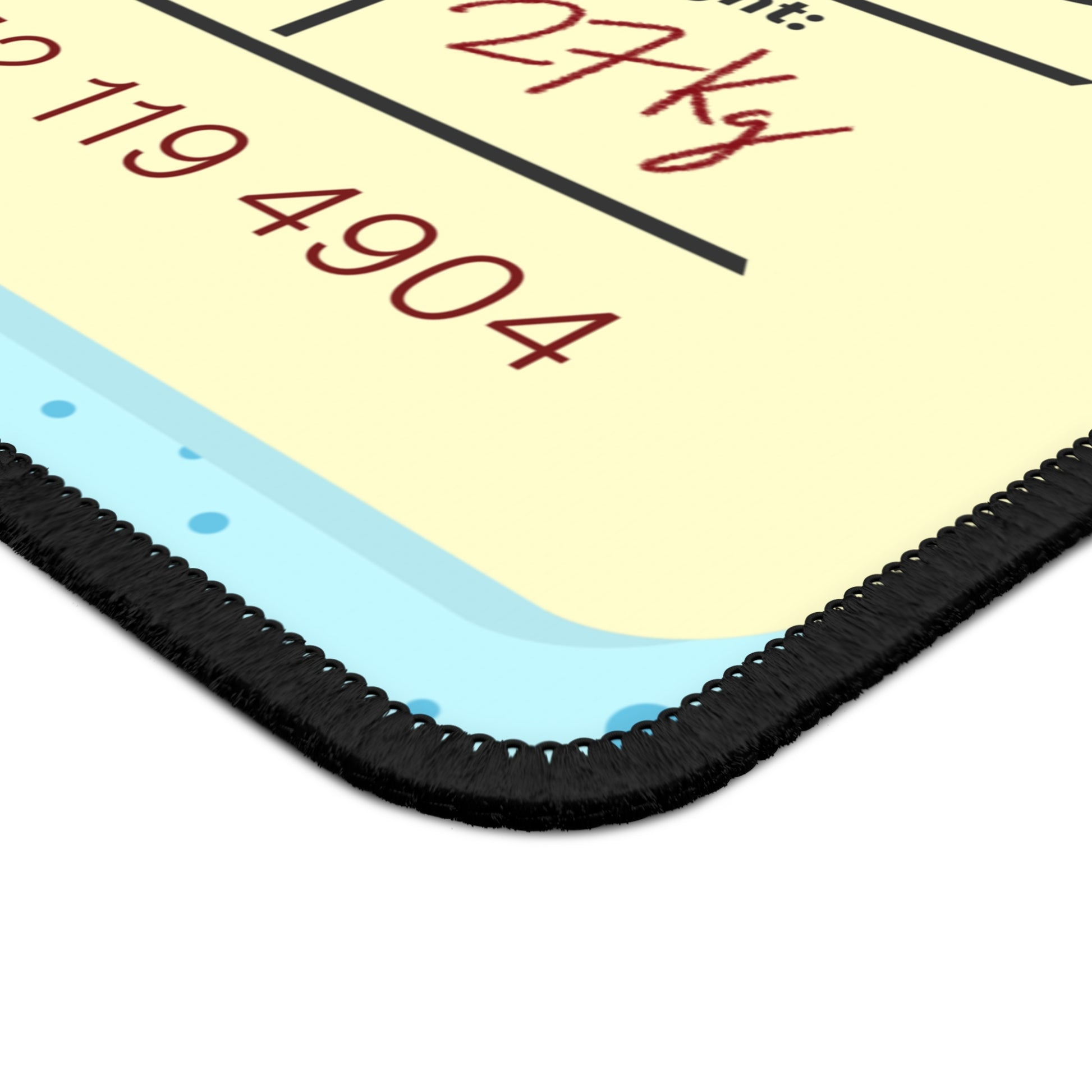 The corner of a gaming mouse pad with a dotted blue background and a blue and yellow Tokyo airline baggage tag on it.