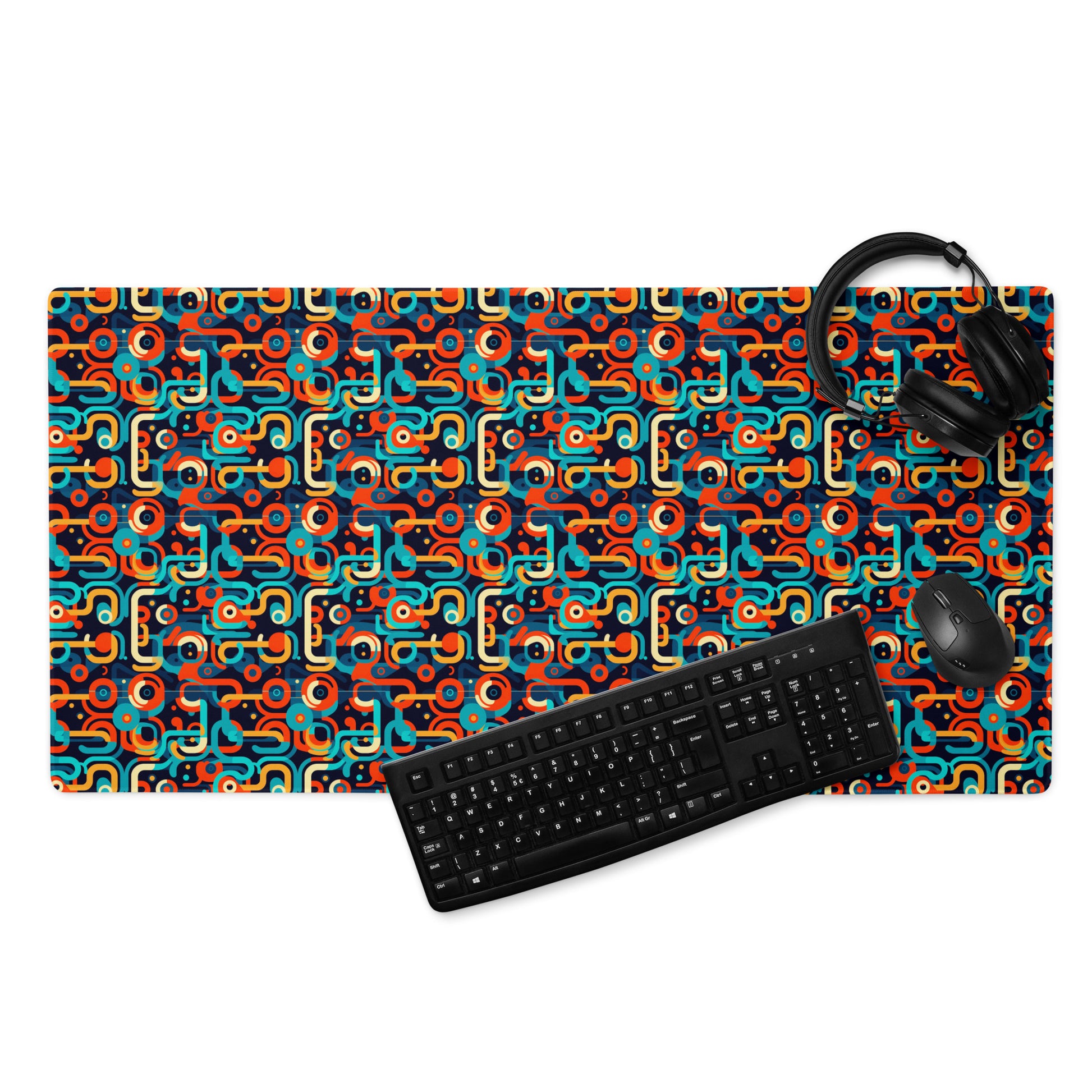 A 36" x 18" gaming desk pad with blue, orange, and beige lines on a black background. A keyboard, mouse, and headphones sit on it.