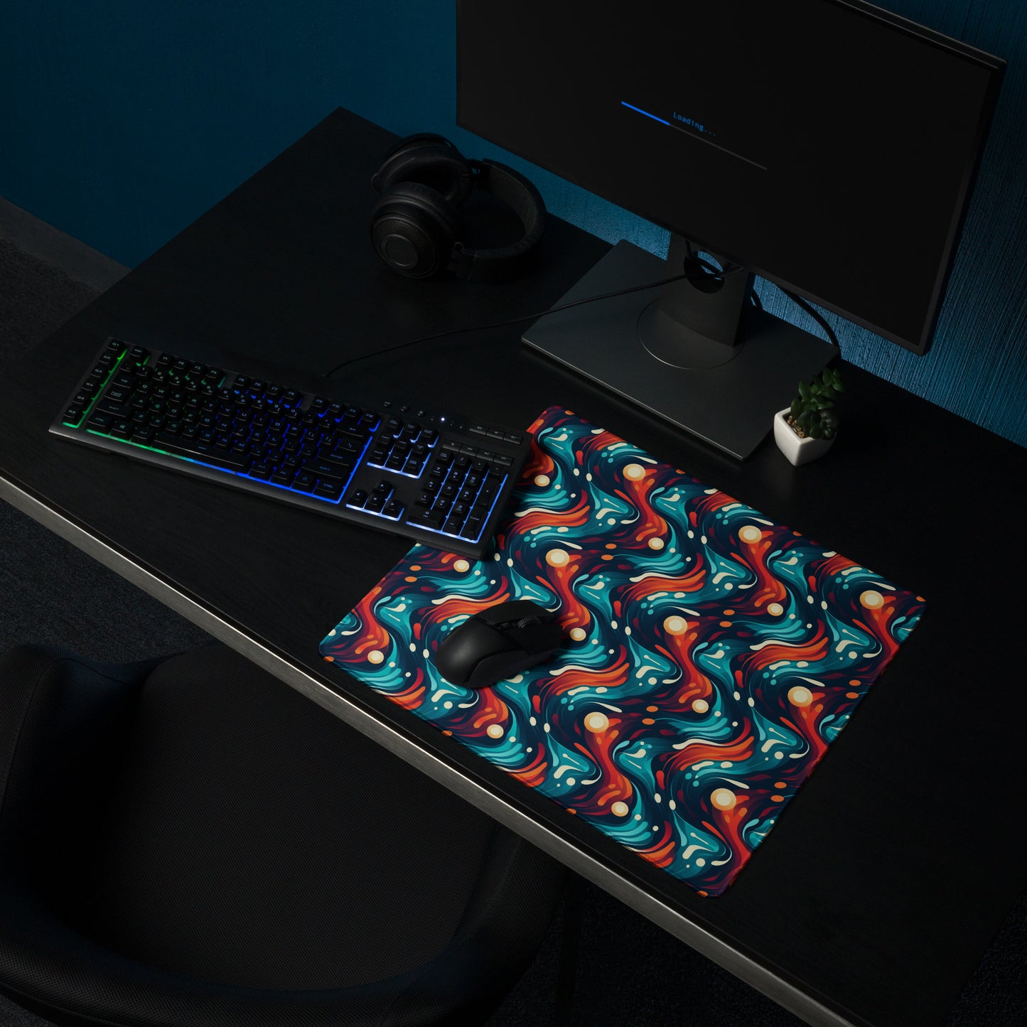 A 18" x 16" desk pad with a blue and orange wavy pattern sitting on a desk.