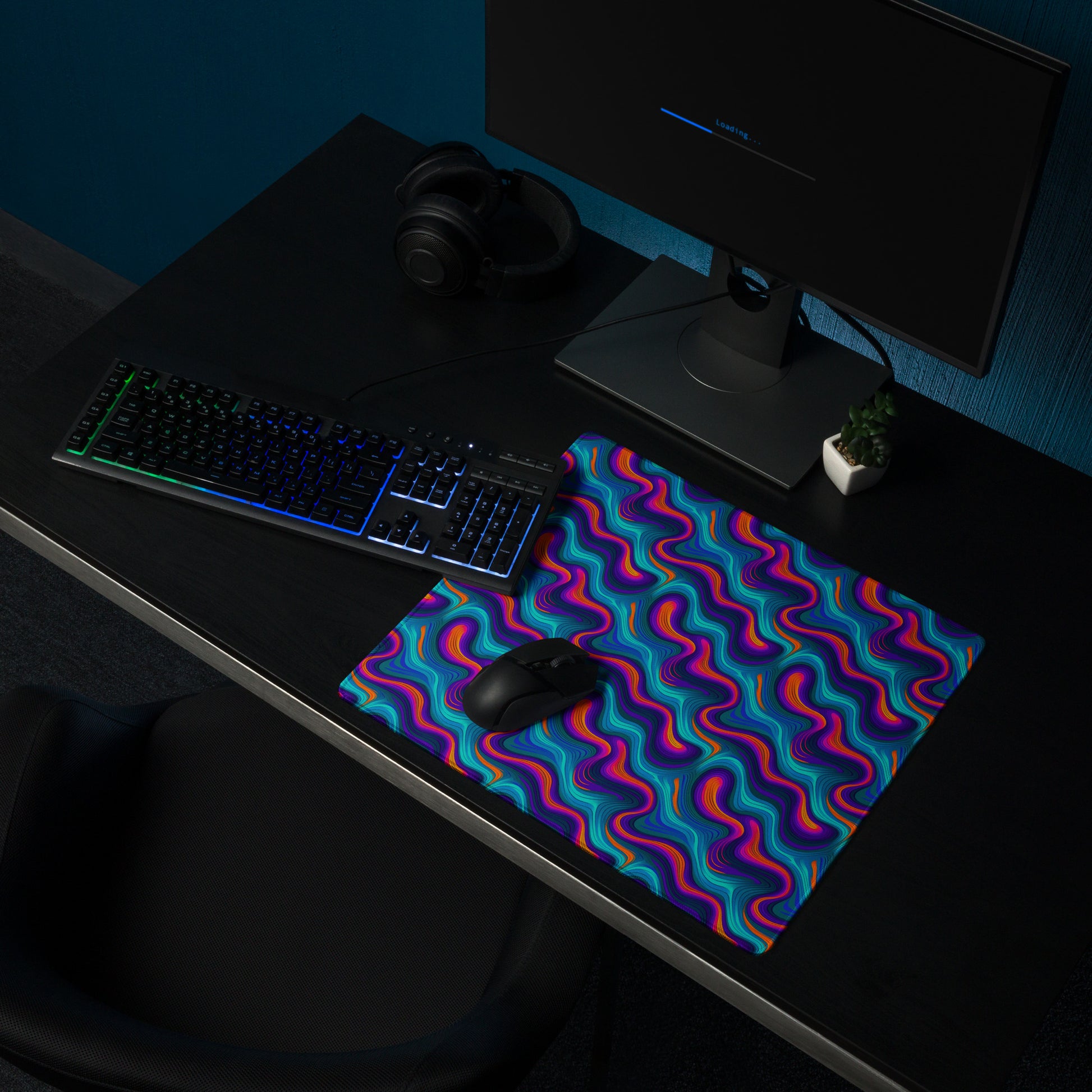 A 18" x 16" desk pad with blue and orange wavy pattern sitting on a desk.