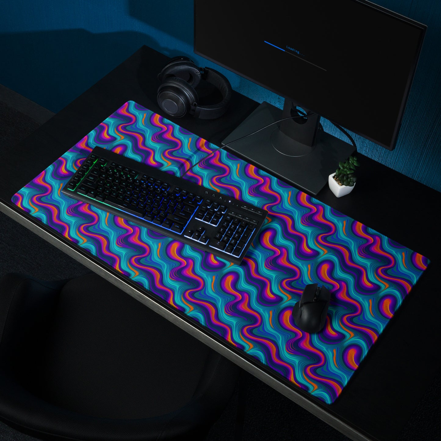 A 36" x 18" desk pad with blue and orange wavy pattern sitting on a desk