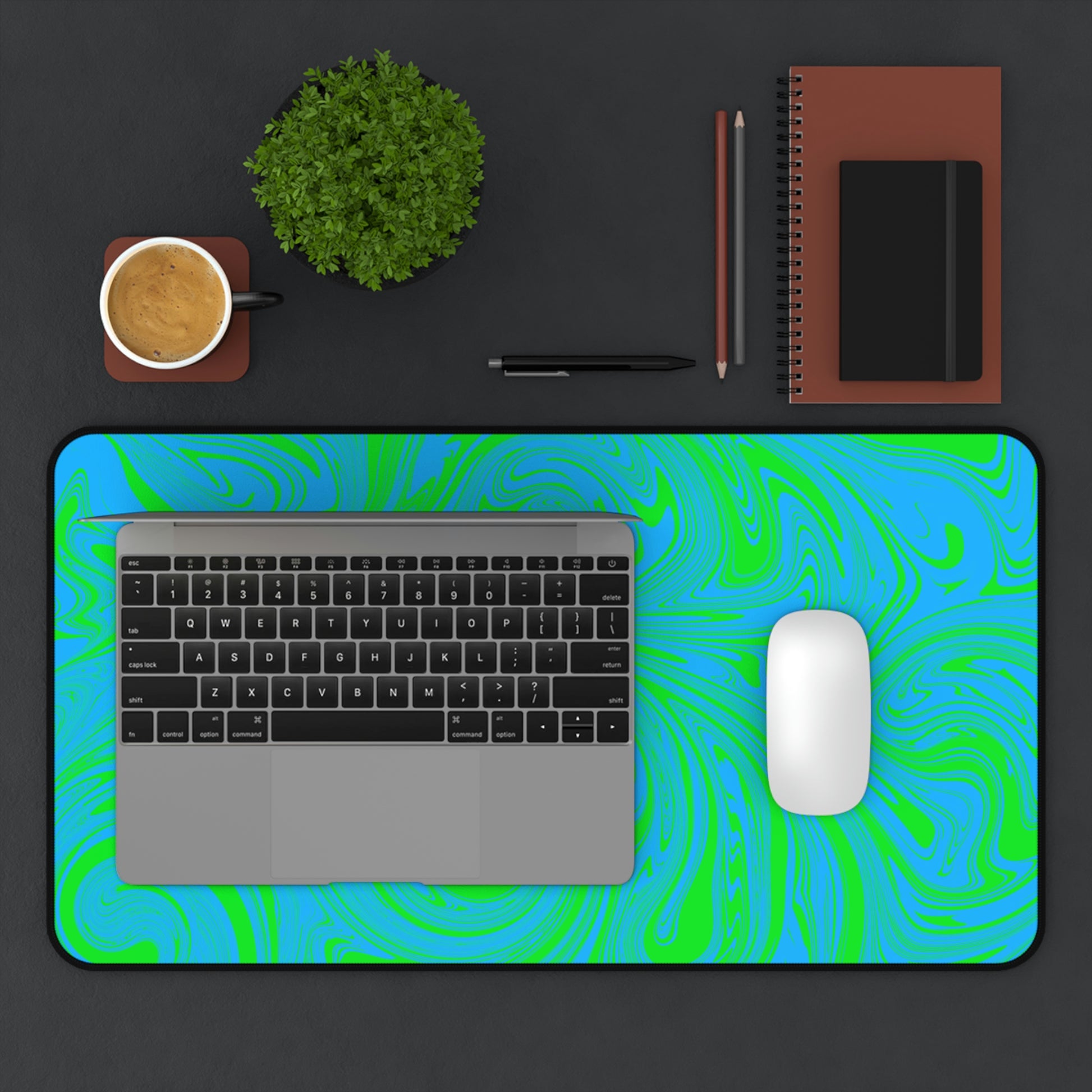 A 12" x 22" desk mat with blue and green swirls. A laptop and mouse sit on top of it.