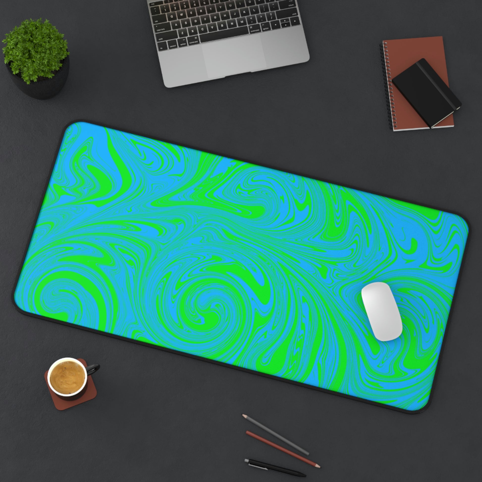 A 31" x 15.5" desk mat with blue and green swirls sitting at an angle.