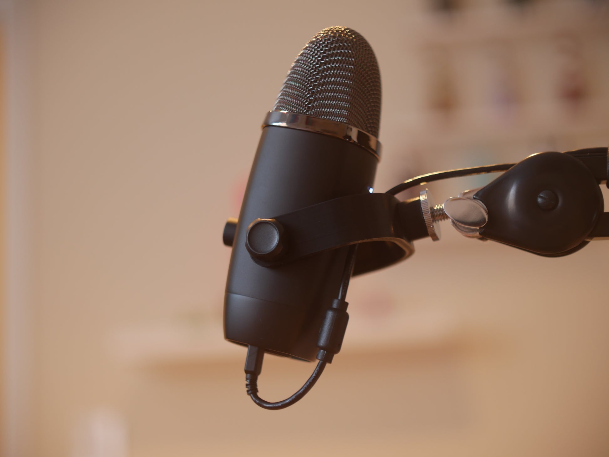 A black microphone mount attached to a boom arm holding a Blue Yeti X microphone.