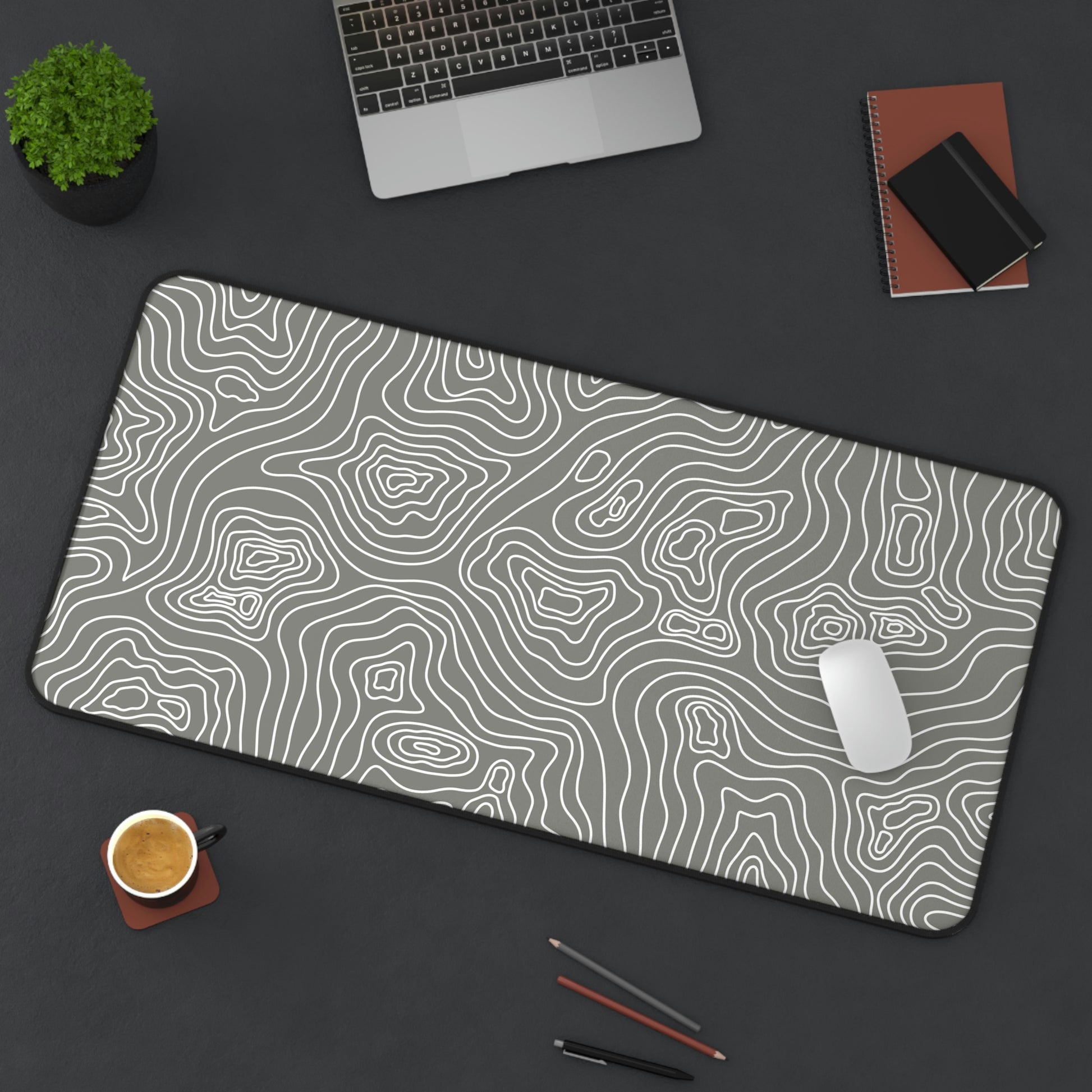 A 31" x 15.5" gray desk mat with white topographic lines sitting at an angle. A mouse sits on top of it.