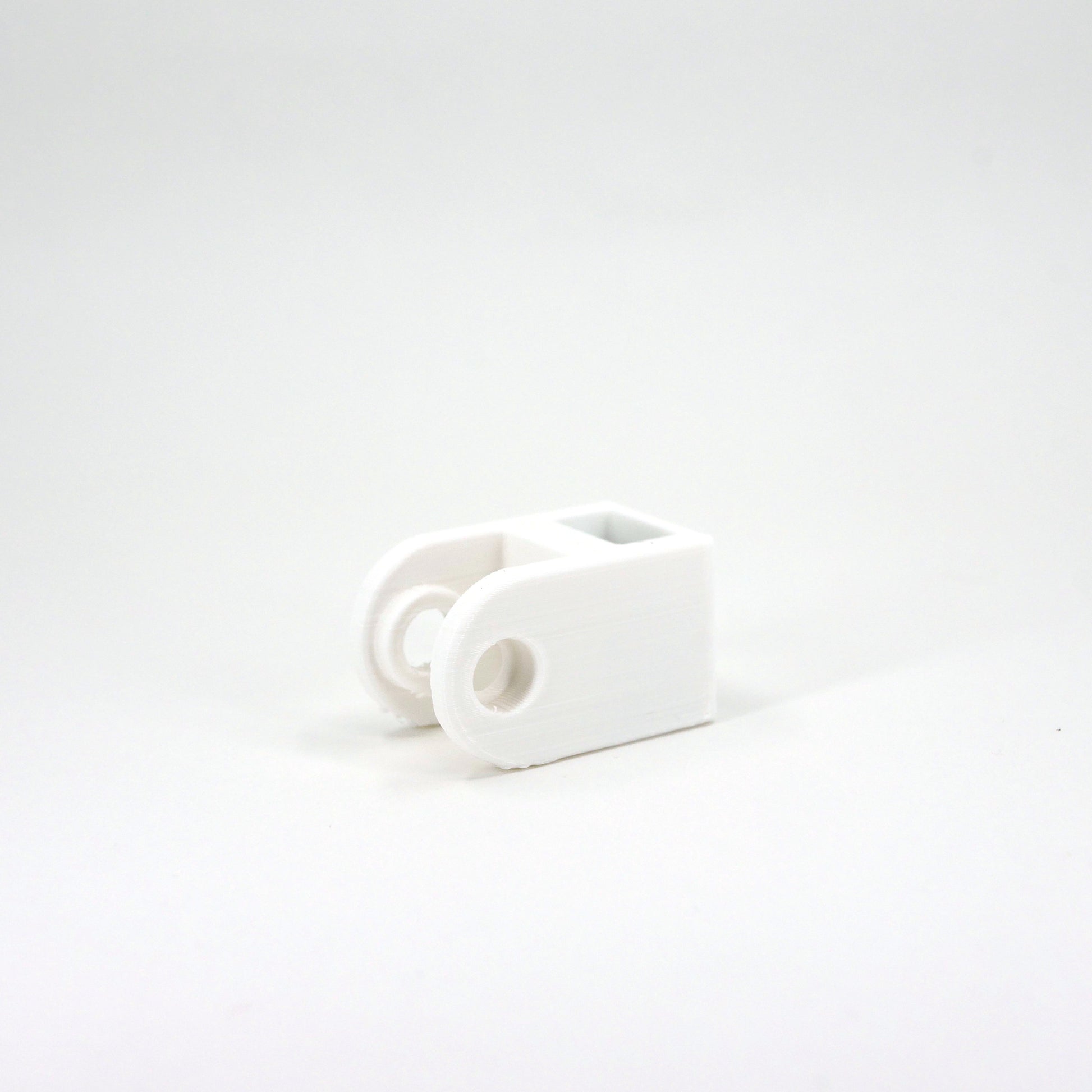 A white HyperX DuoCast microphone mount adapter.