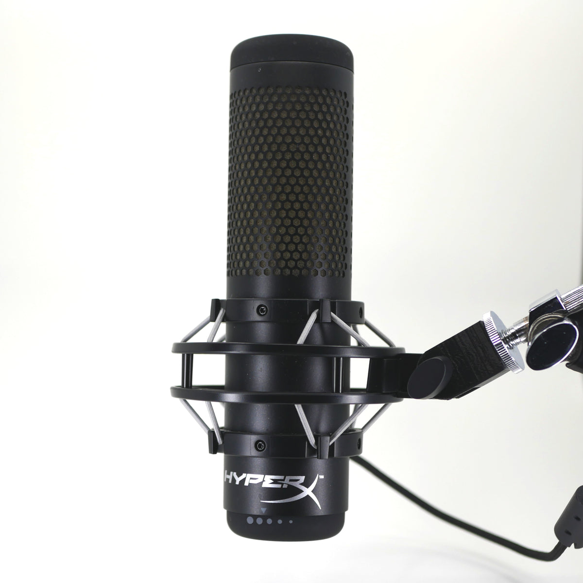 A black HyperX QuadCast microphone mount adapter attached to a boom arm and holding the HyperX QuadCast microphone.