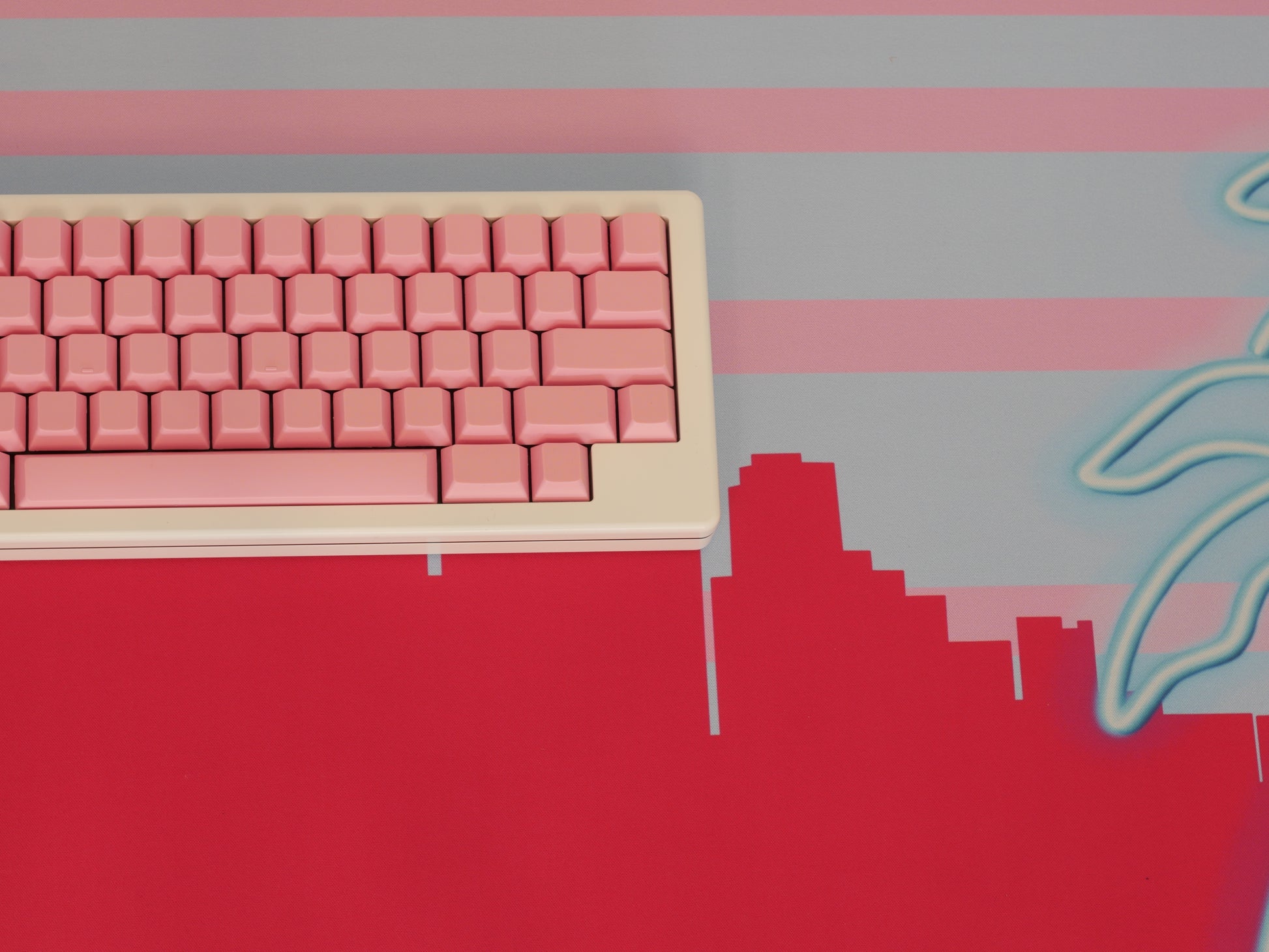 Middle of the pink and blue Miami skyline desk mat. A white keyboard with pink keycaps sits on top of it.