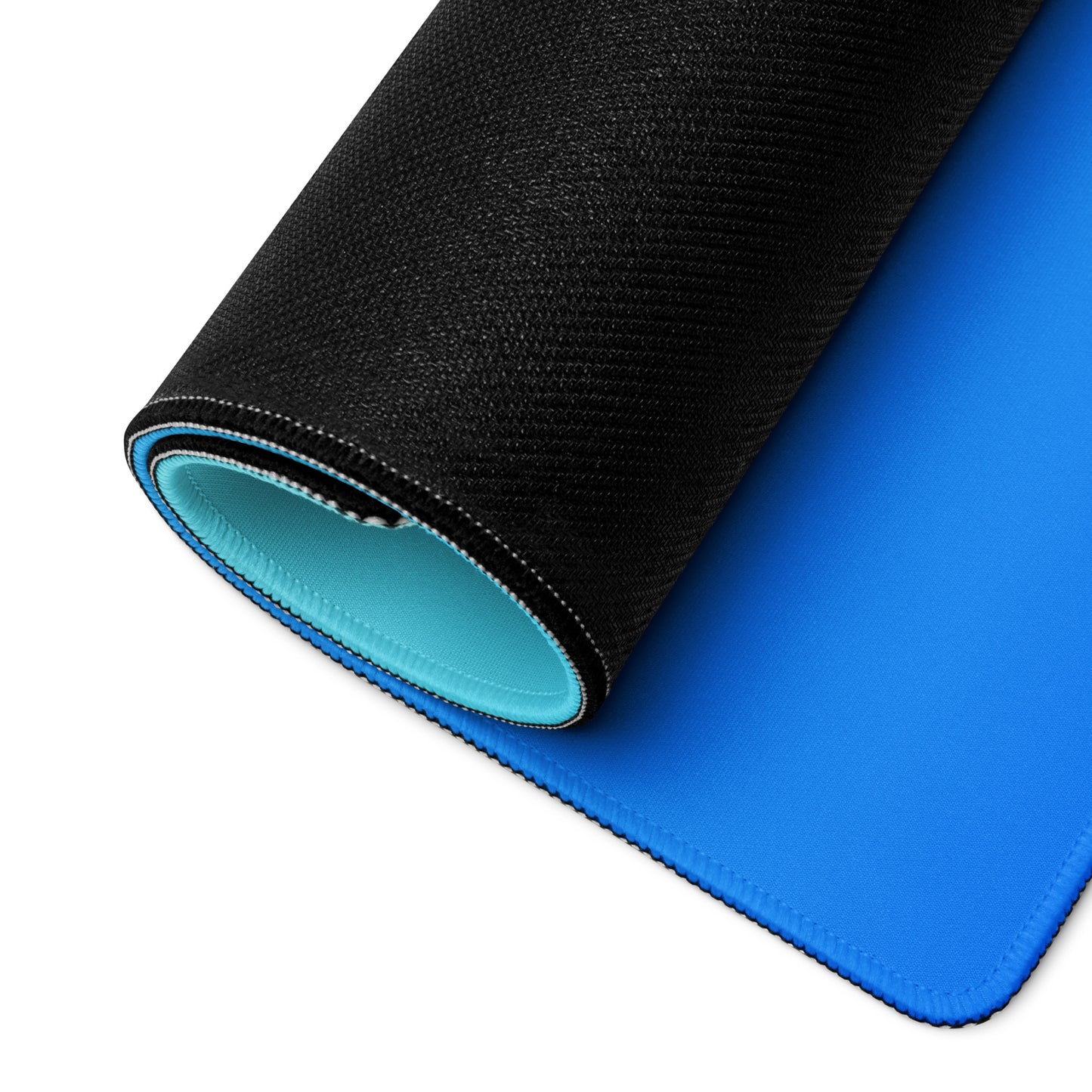 A gaming desk pad with dark blue at the bottom and light blue at the top. The desk pad is rolled up.